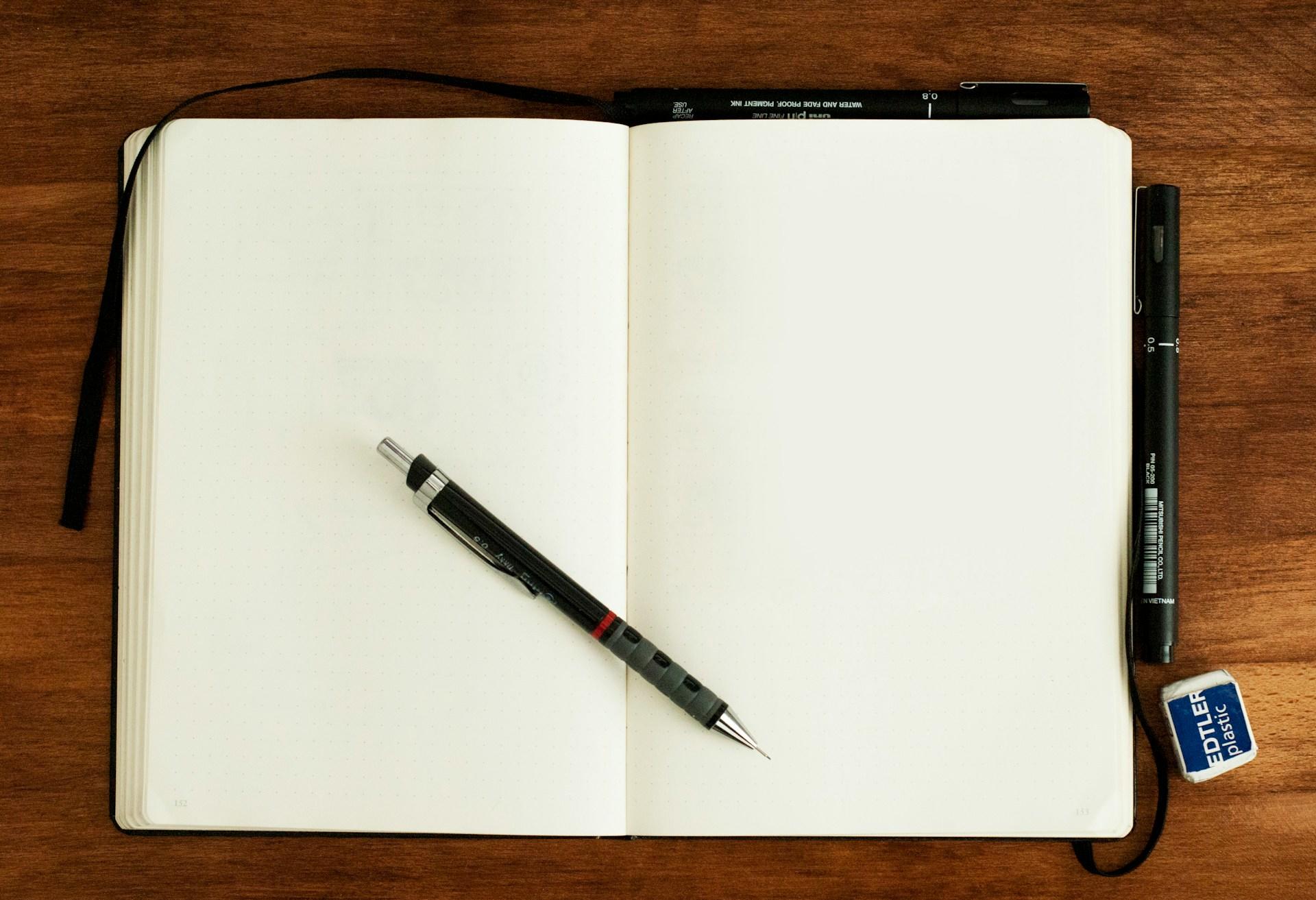 Åpen notatbok med penn inni.