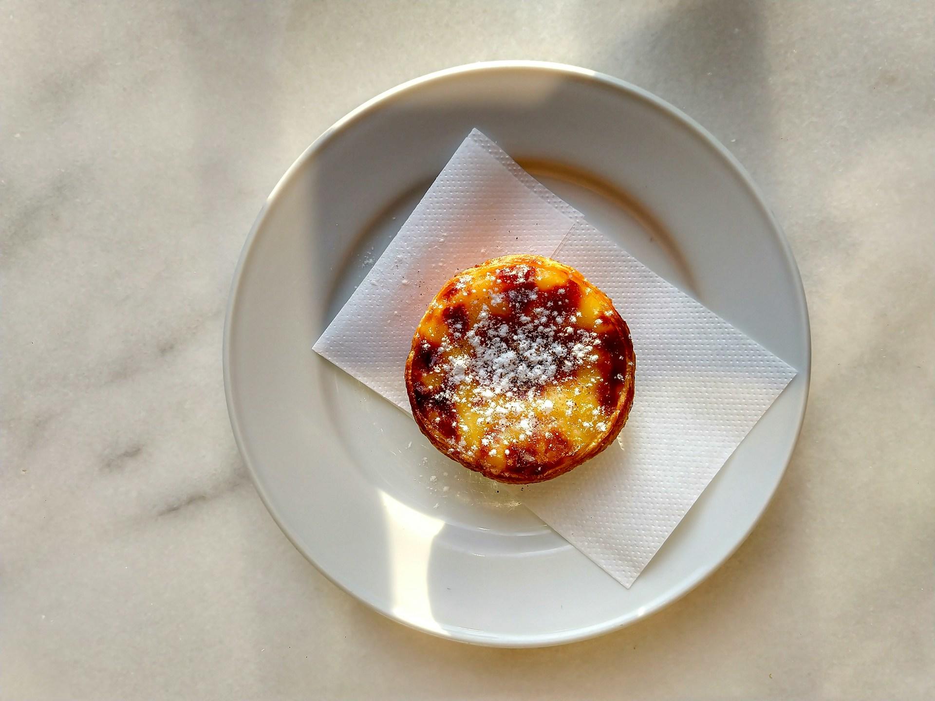 Hvit tallerken med Pastel de Nata på.