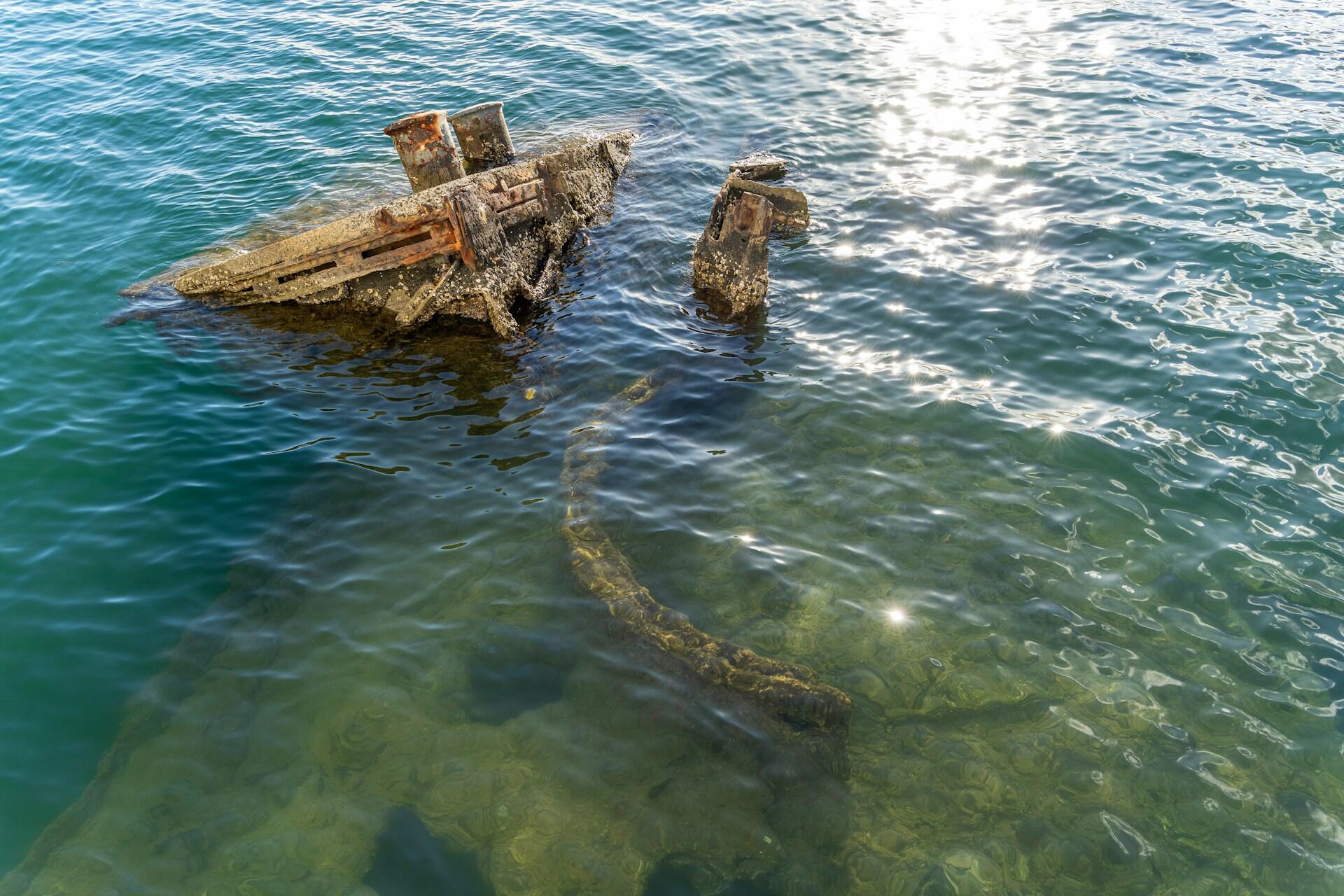 Rustent vrak av krigsskip stikker opp fra havet ved Pearl Harbor i Honolul