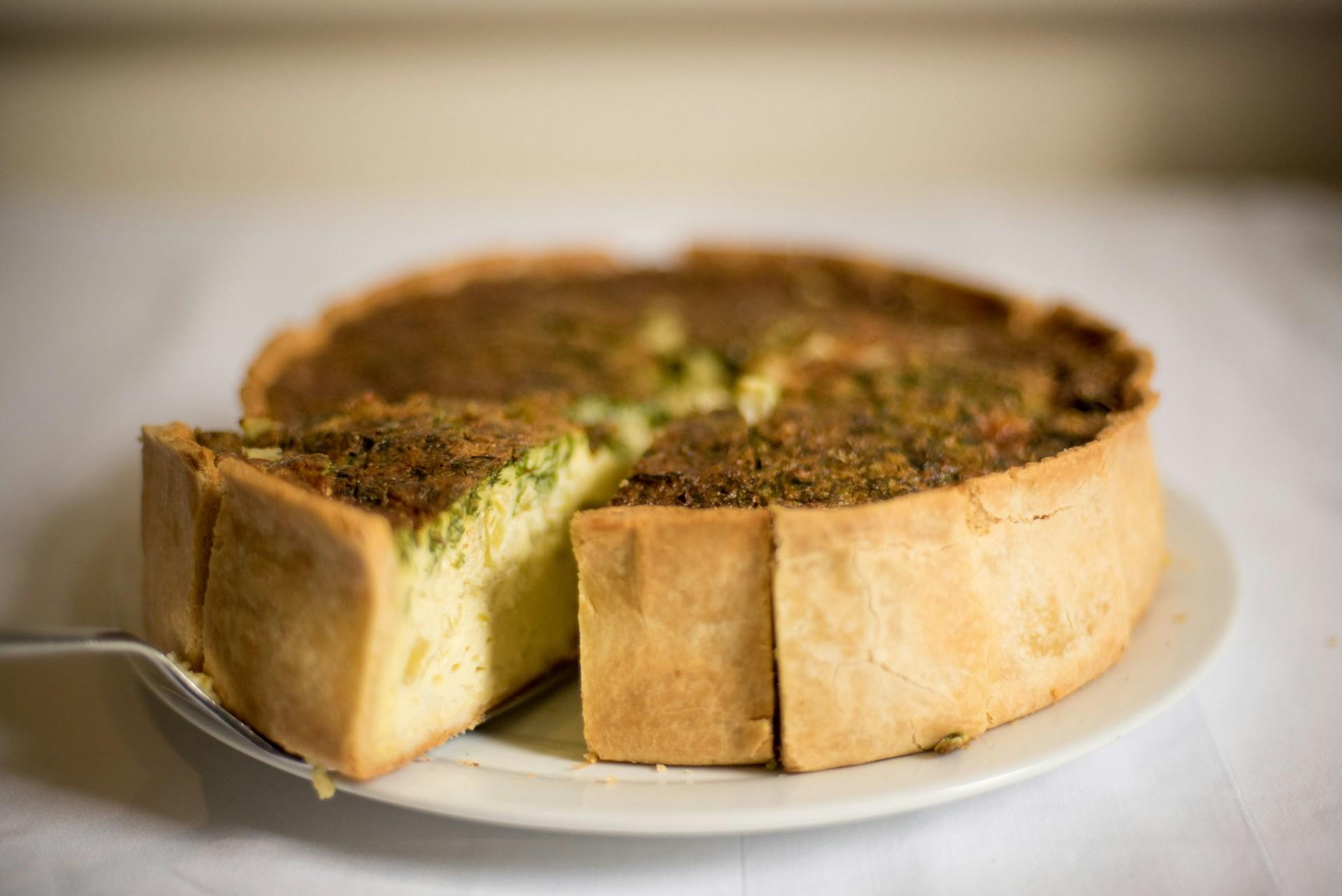 Quiche Lorraine pai skjæres opp på fat.