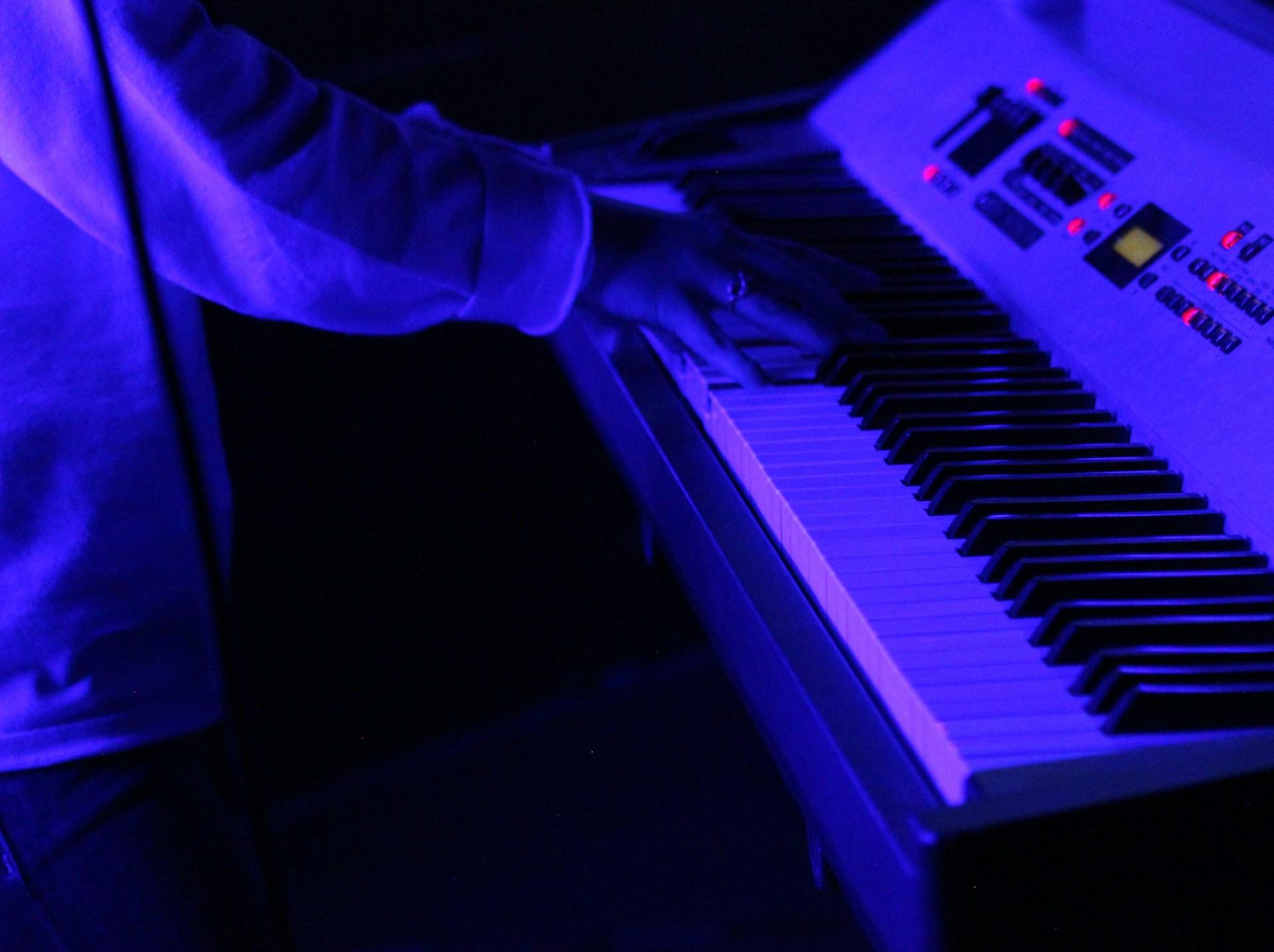 Person spiller på elektrisk piano.
