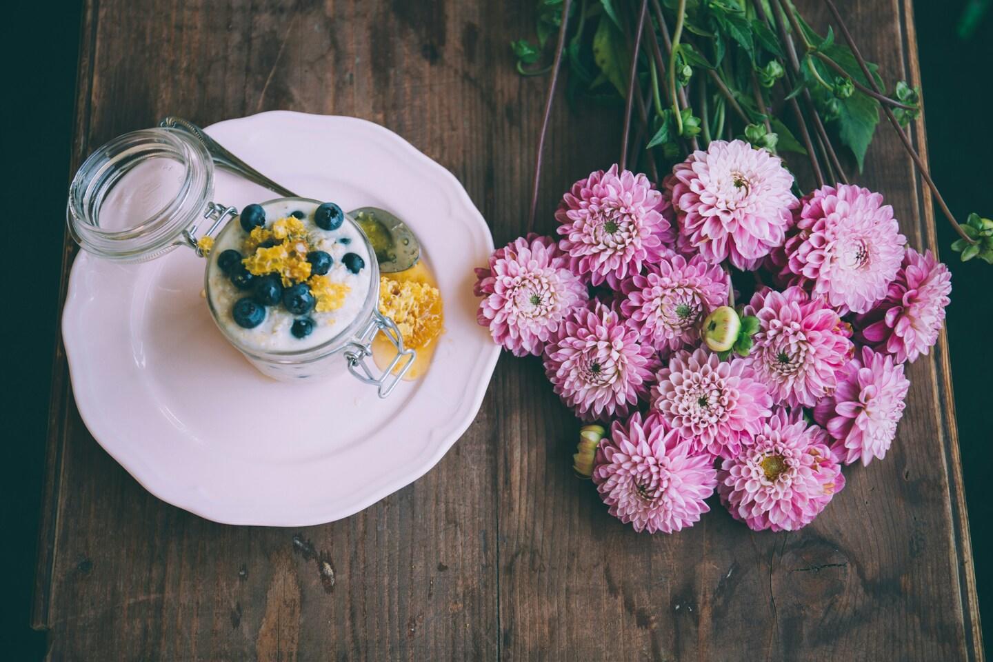 Yoghurt med frukt og honning på en tallerken.