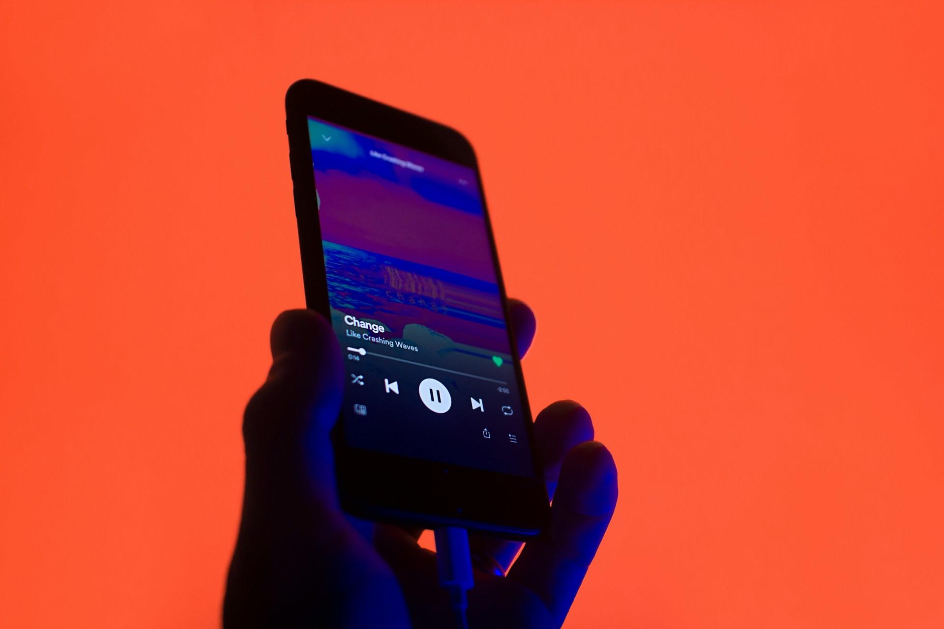 Person holder telefon med Spotify oppe.