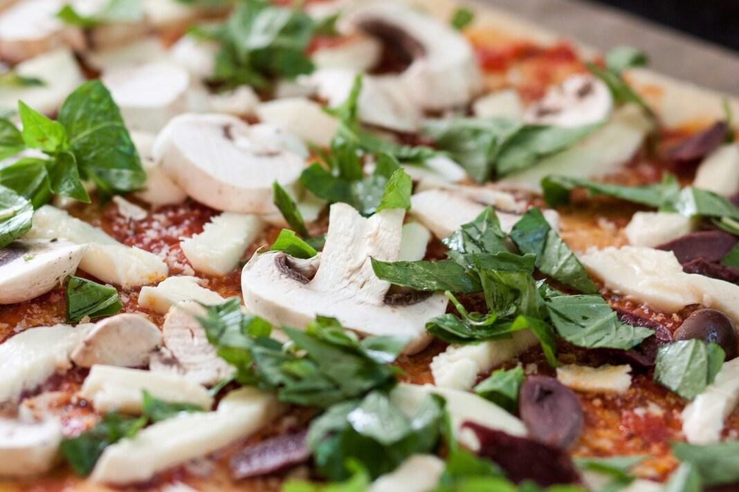 Grønnsakspizza med sopp og basilikum.