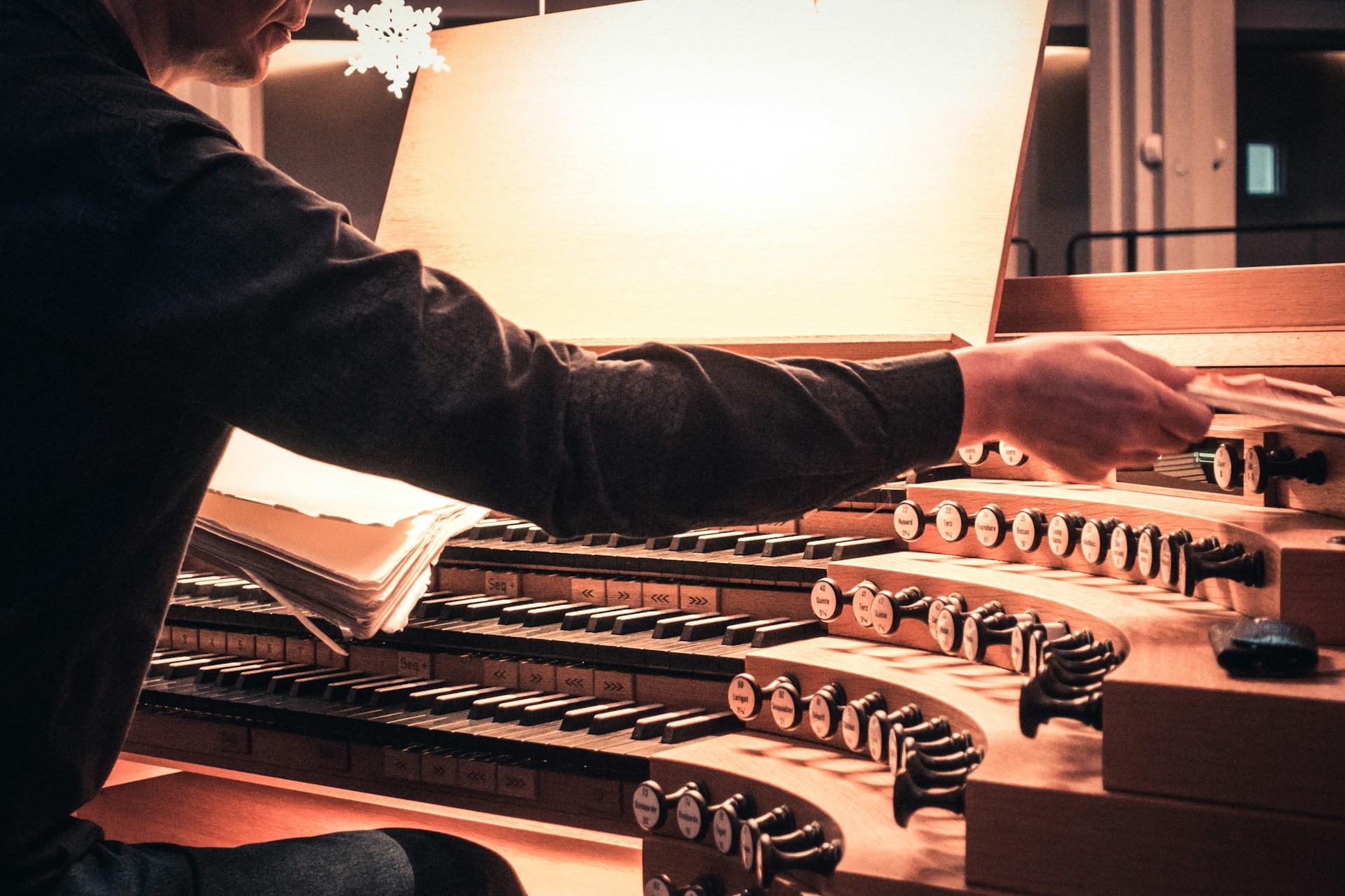 Mann spiller på et orgel.