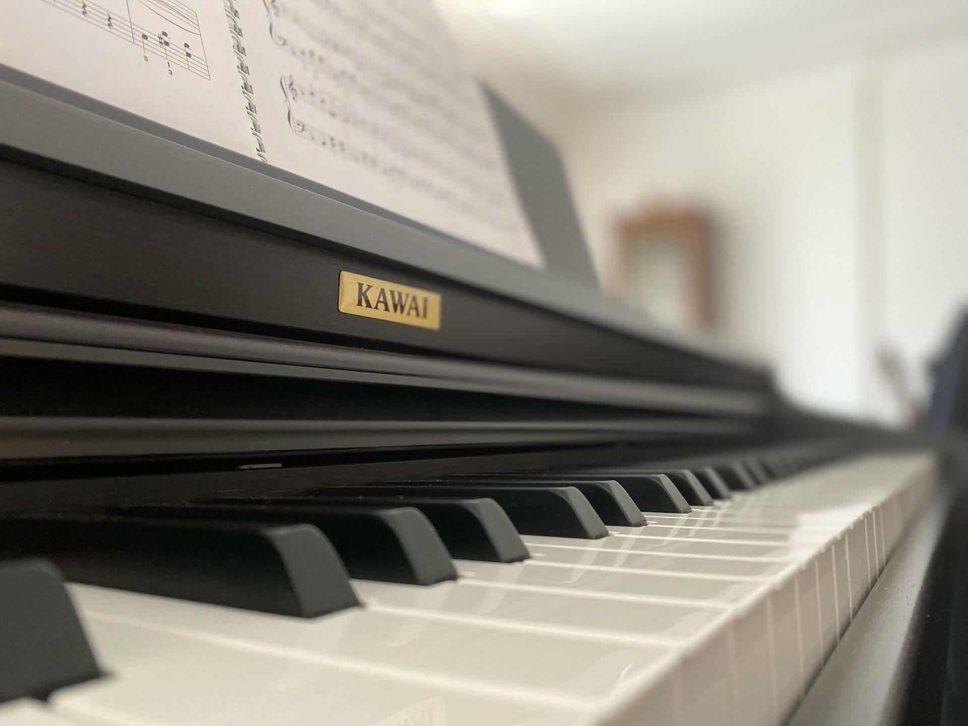Nærbilde av sort piano med noter over.