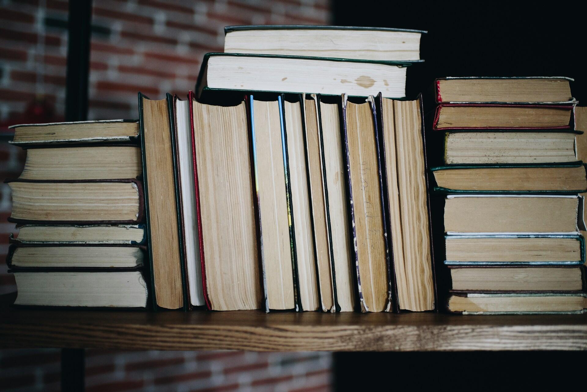 Kvinne leser en bok mens hun sitter på en buss, med utsikt gjennom vinduet.