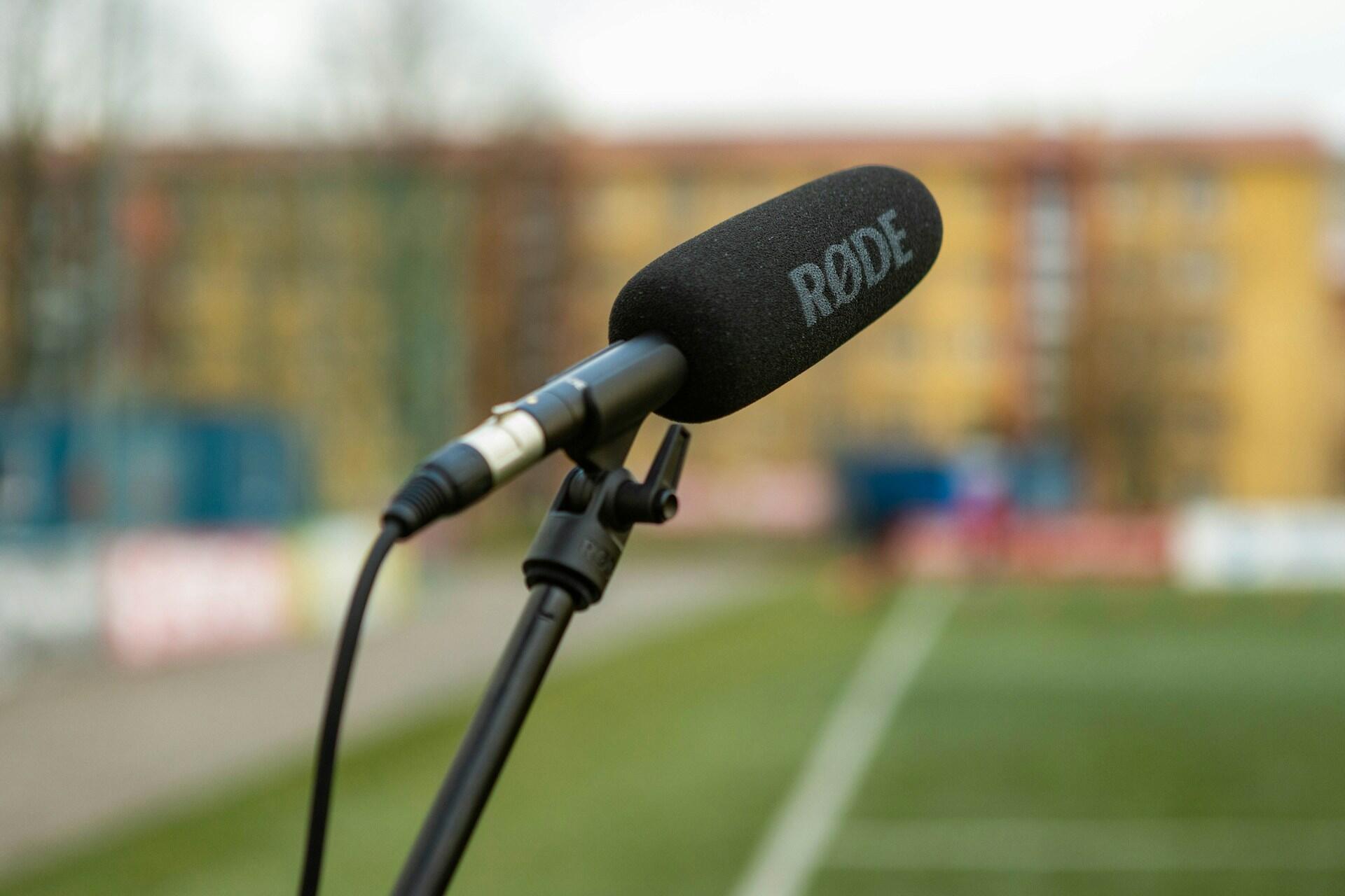 En mikrofon står klar på et podium, forberedt til en tale eller intervju.