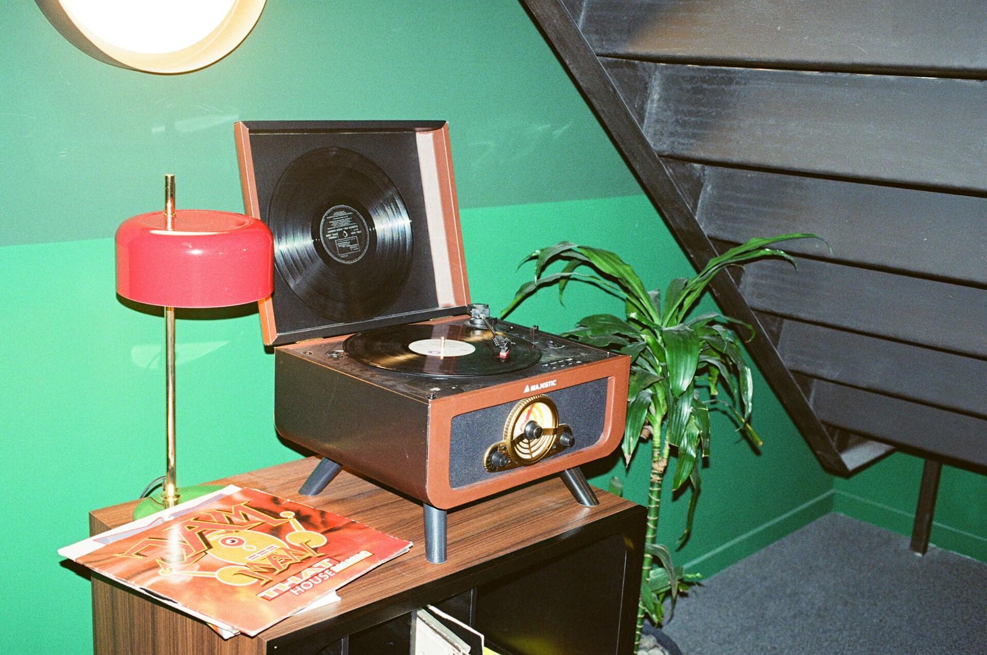 Vintage platespiller med vinylplater og retrointeriør, symbolsk for 1970-tallets musikkultur.