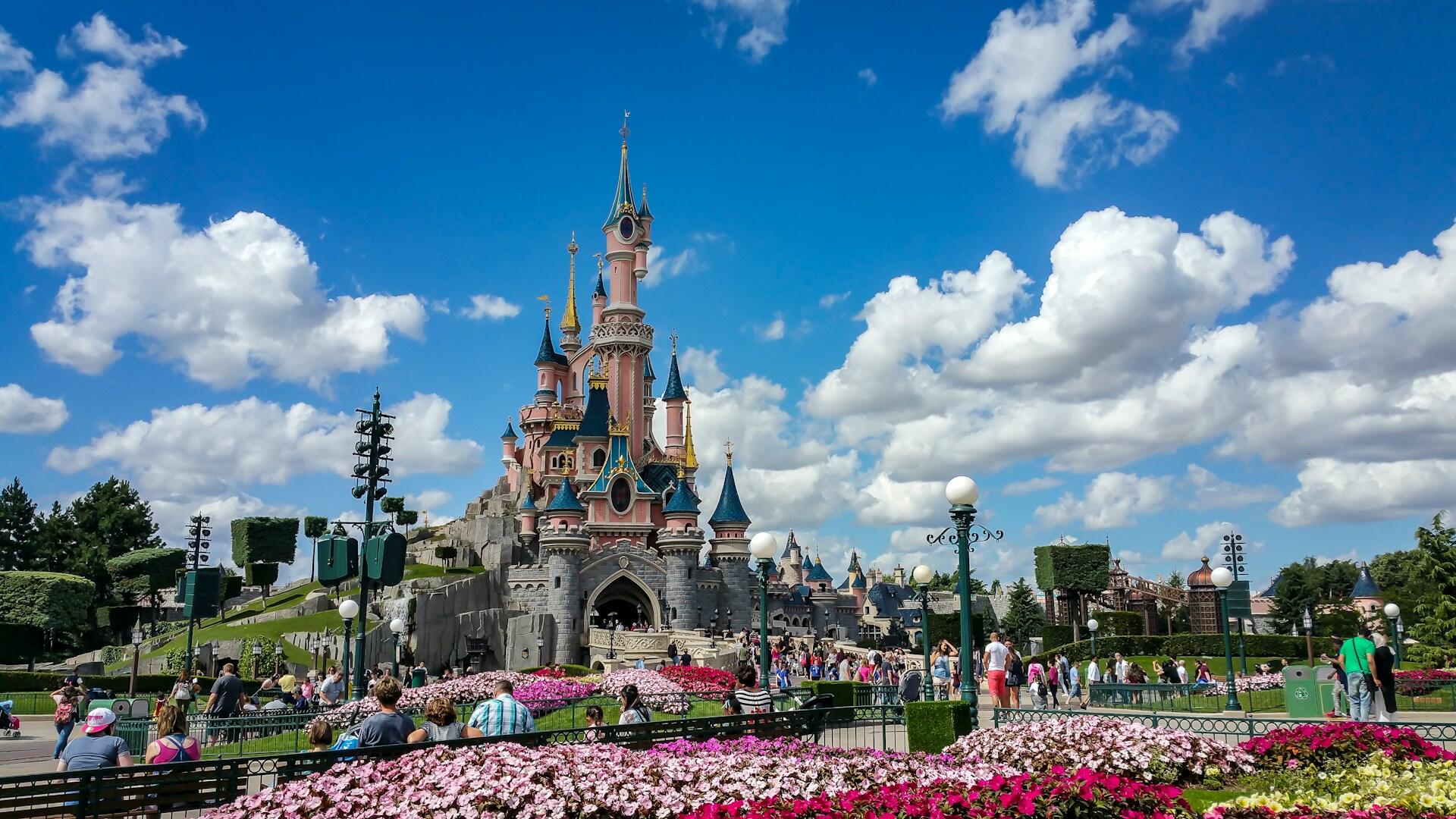 Slott i Disneyland Paris med rosa blomster foran.
