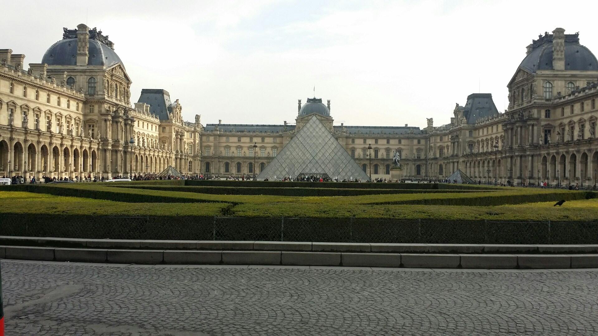 Stort palass i Paris, med Louvre pyramiden foran.