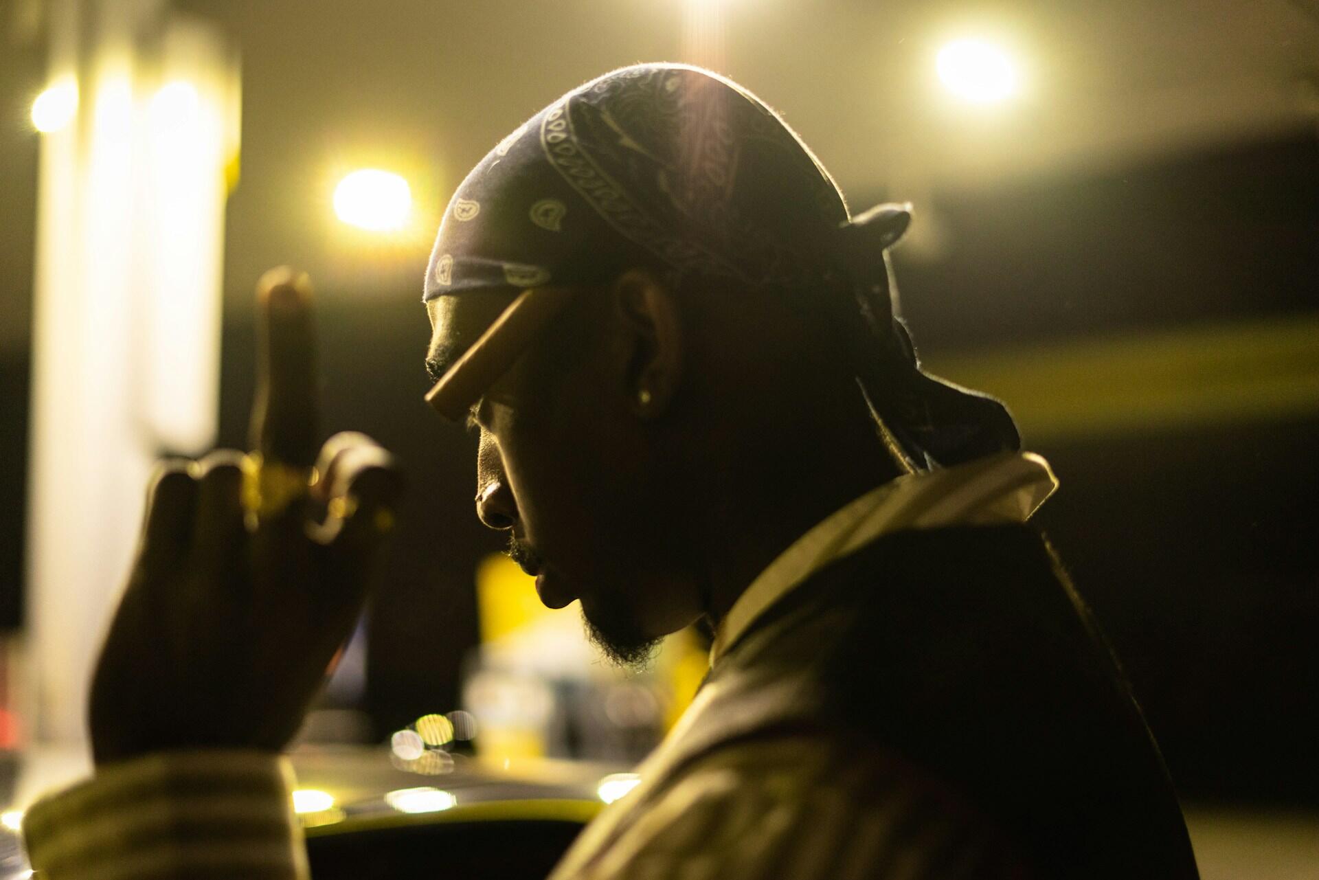 Tupac Shakur i bandana og mørkt lys, ikonisk for 90-talls hiphop.
