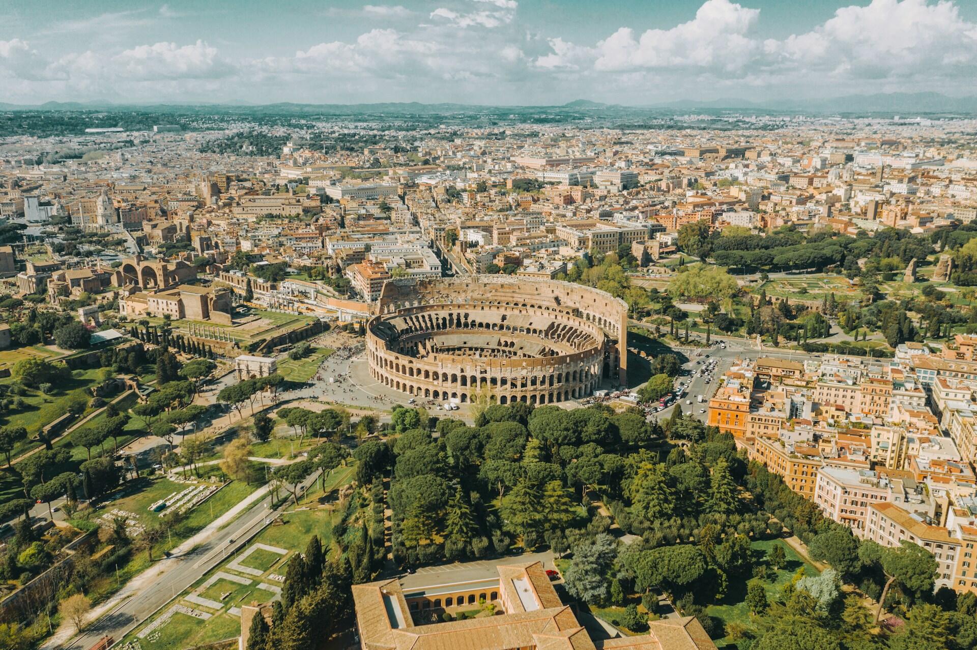 Oversiktsbilde av Roma, hvor man ser Colosseum tydelig i sentrum.