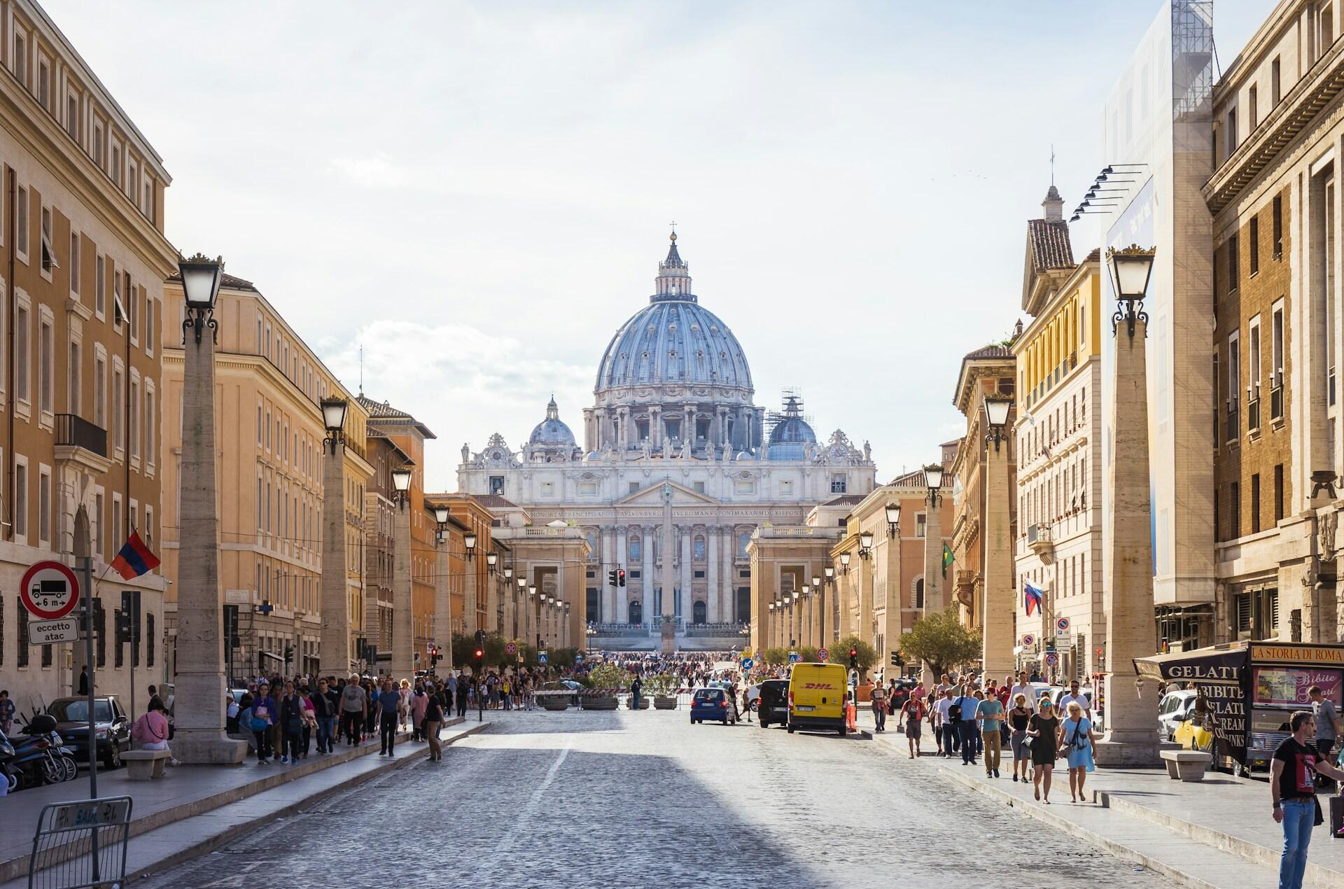 Travel handlegate i Roma med stort bygg med kuppel i bakgrunnen.