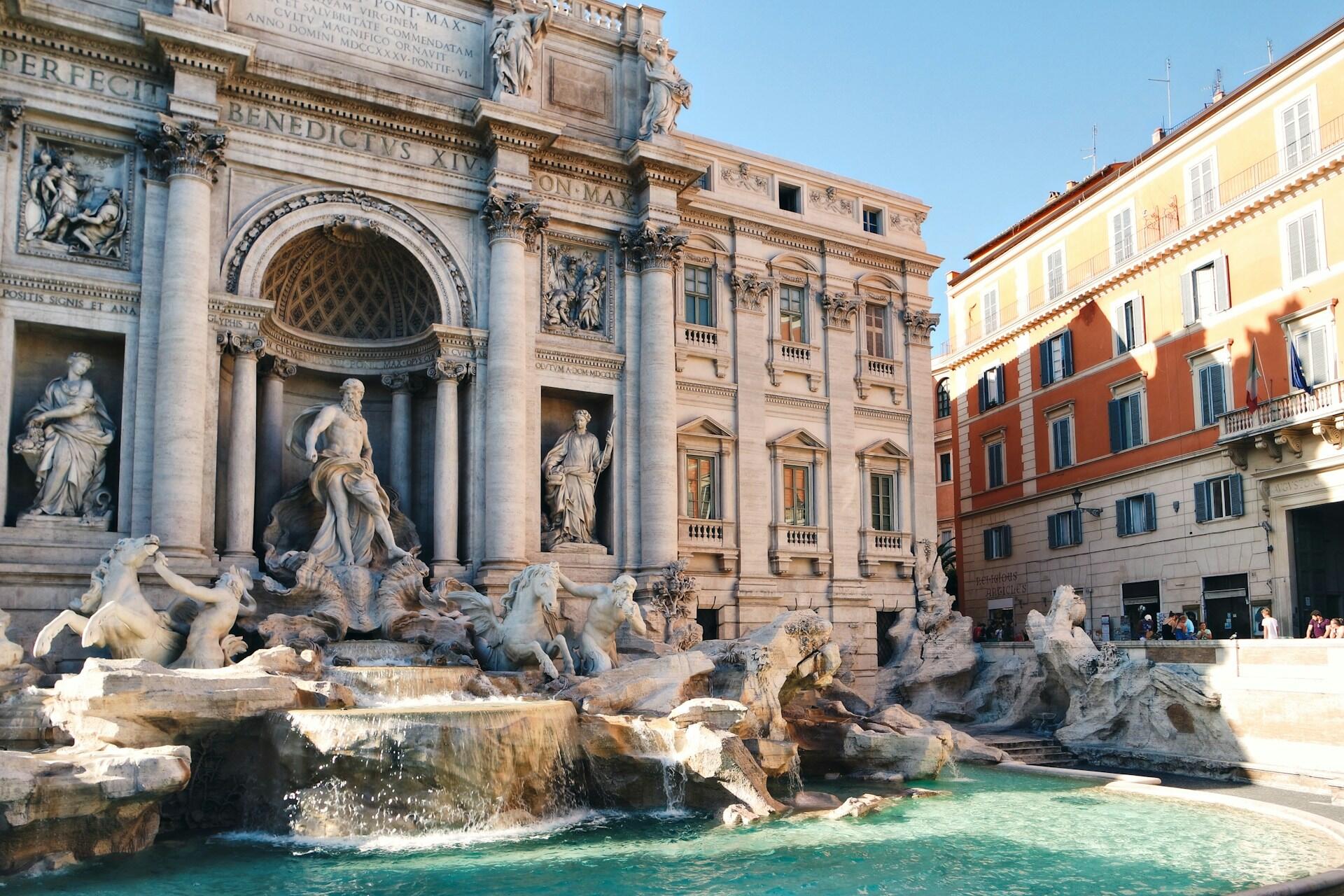 Trevifontenen i Roma med flotte skulpturer og blått vann.