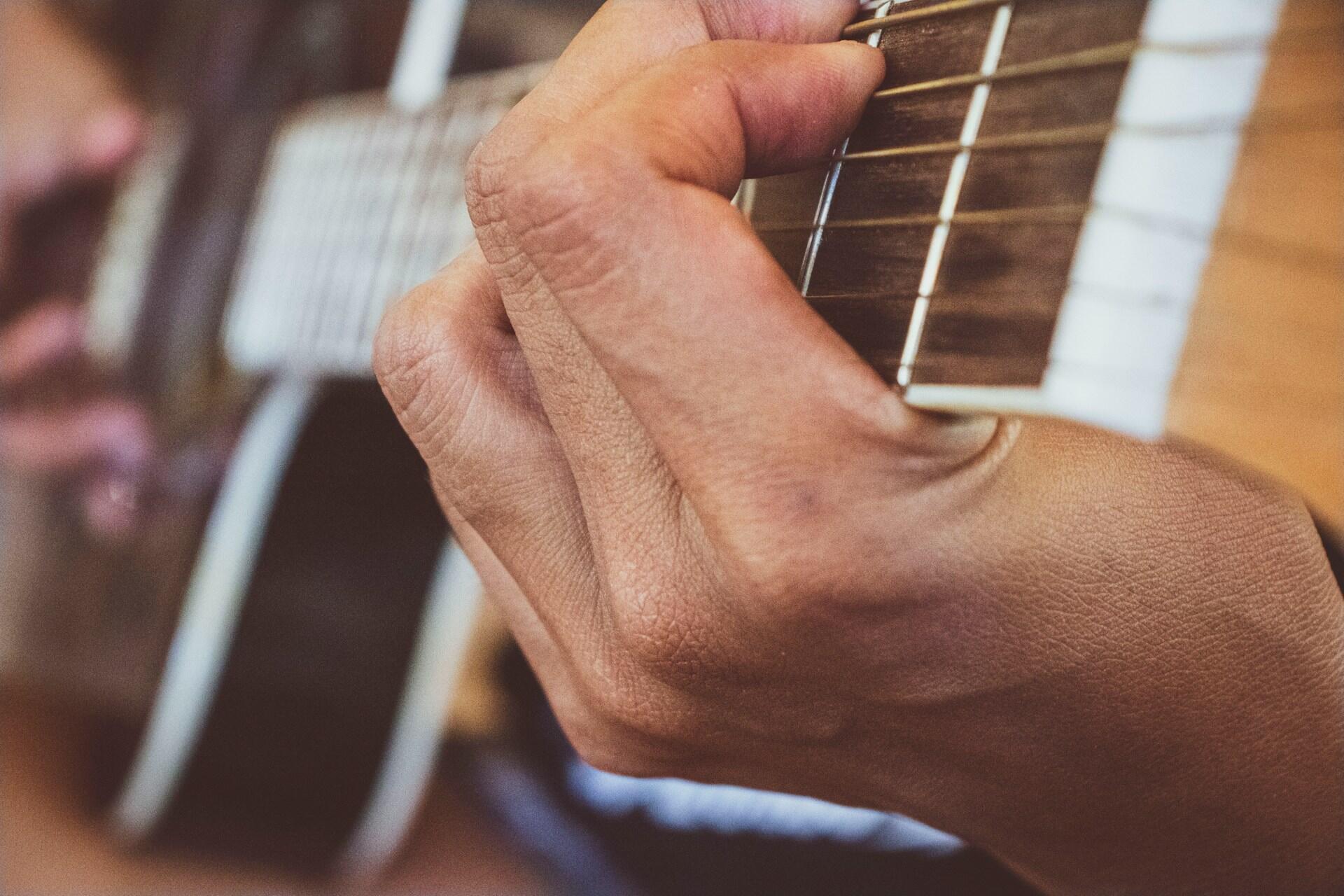 Nærbilde av hånd som holder et grep på gitarhalsen