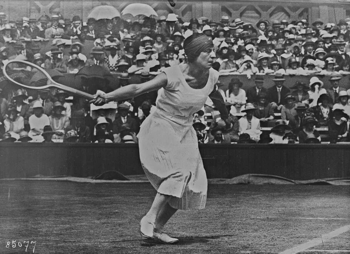 Gammelt bilde i svart og hvitt viser dame som spiller tennis.