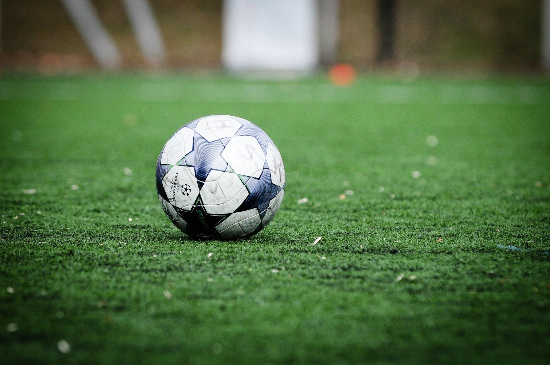 Fotball med stjerner ligger på gresset