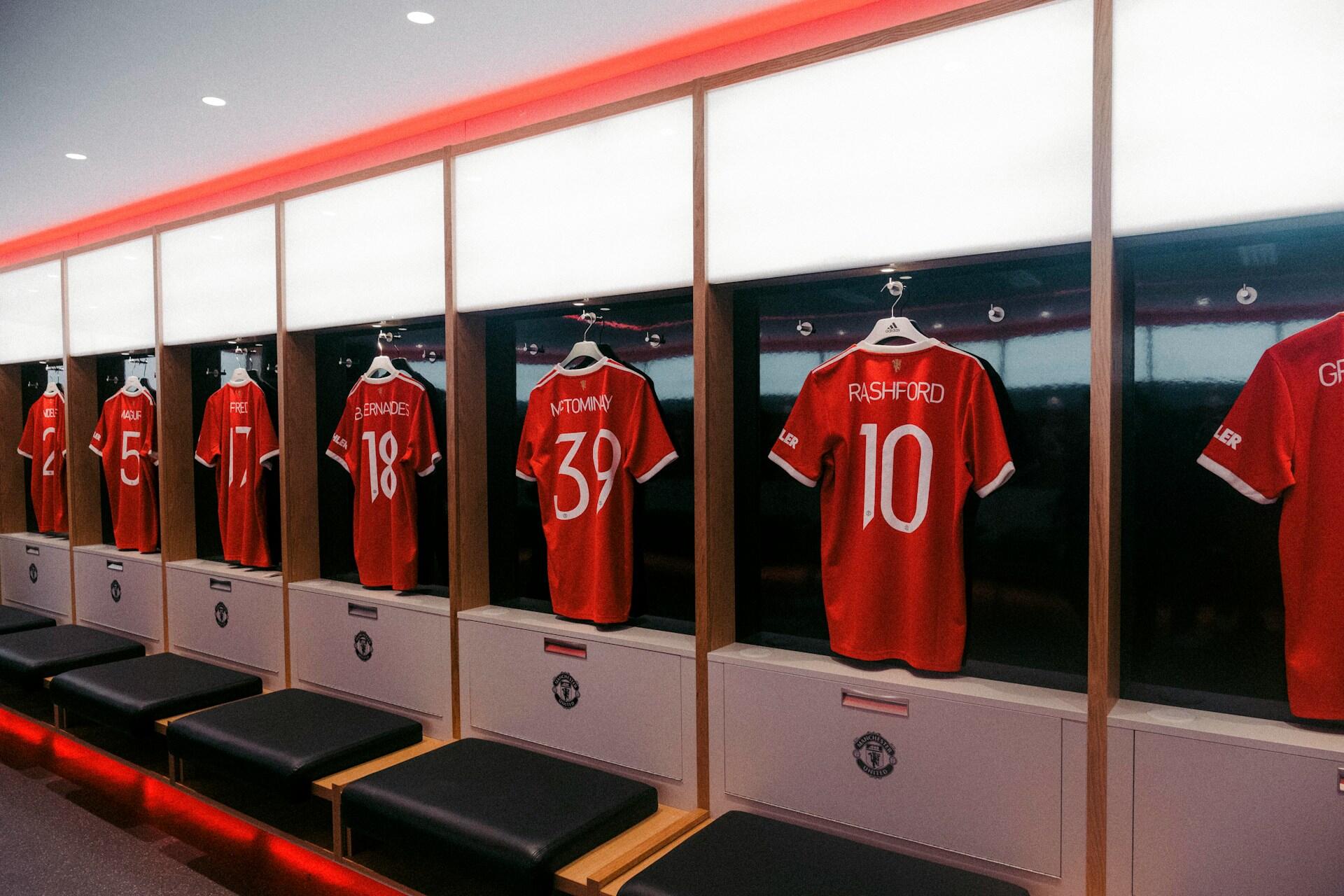 Røde fotballdrakter for spillere p Manchester United henger på rekke og rad i garderoben.