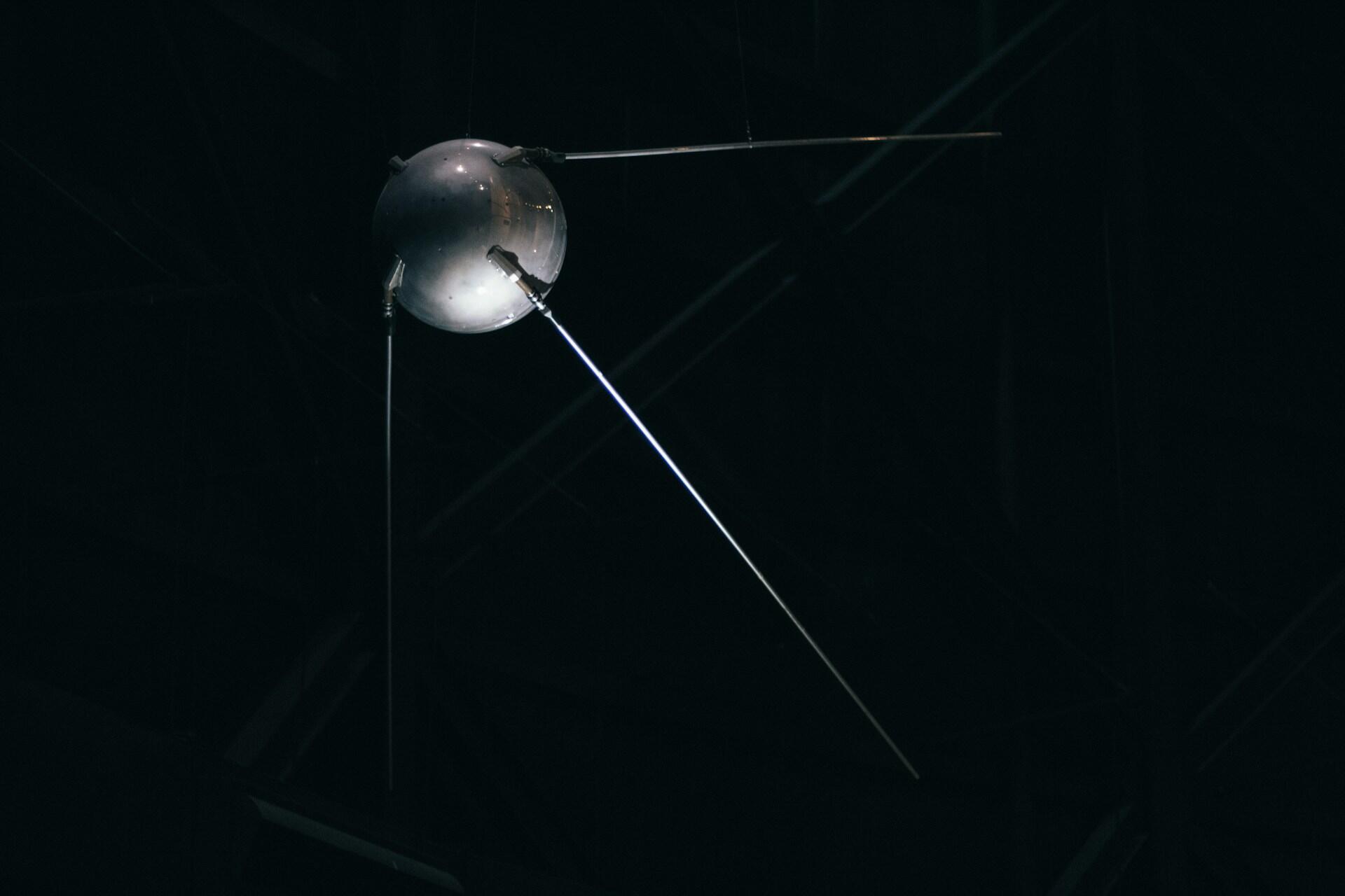 Sputnik 1 satellitten med fire antenner mot mørk bakgrunn