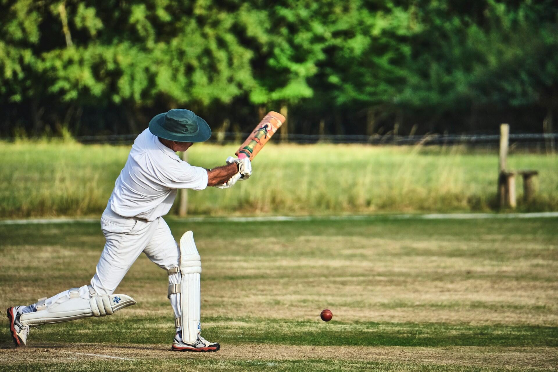 Mann i hvitt slår etter cricketball