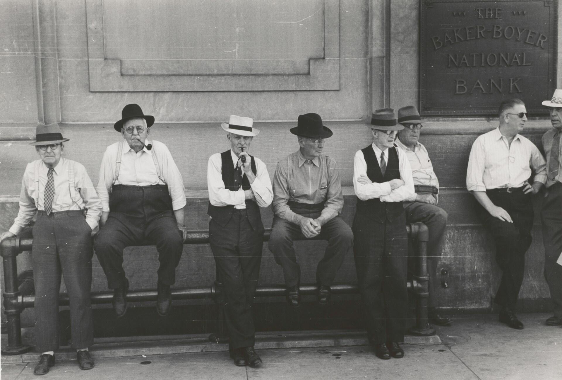 Menn sitter foran en bank under depresjonen på 1930-tallet.