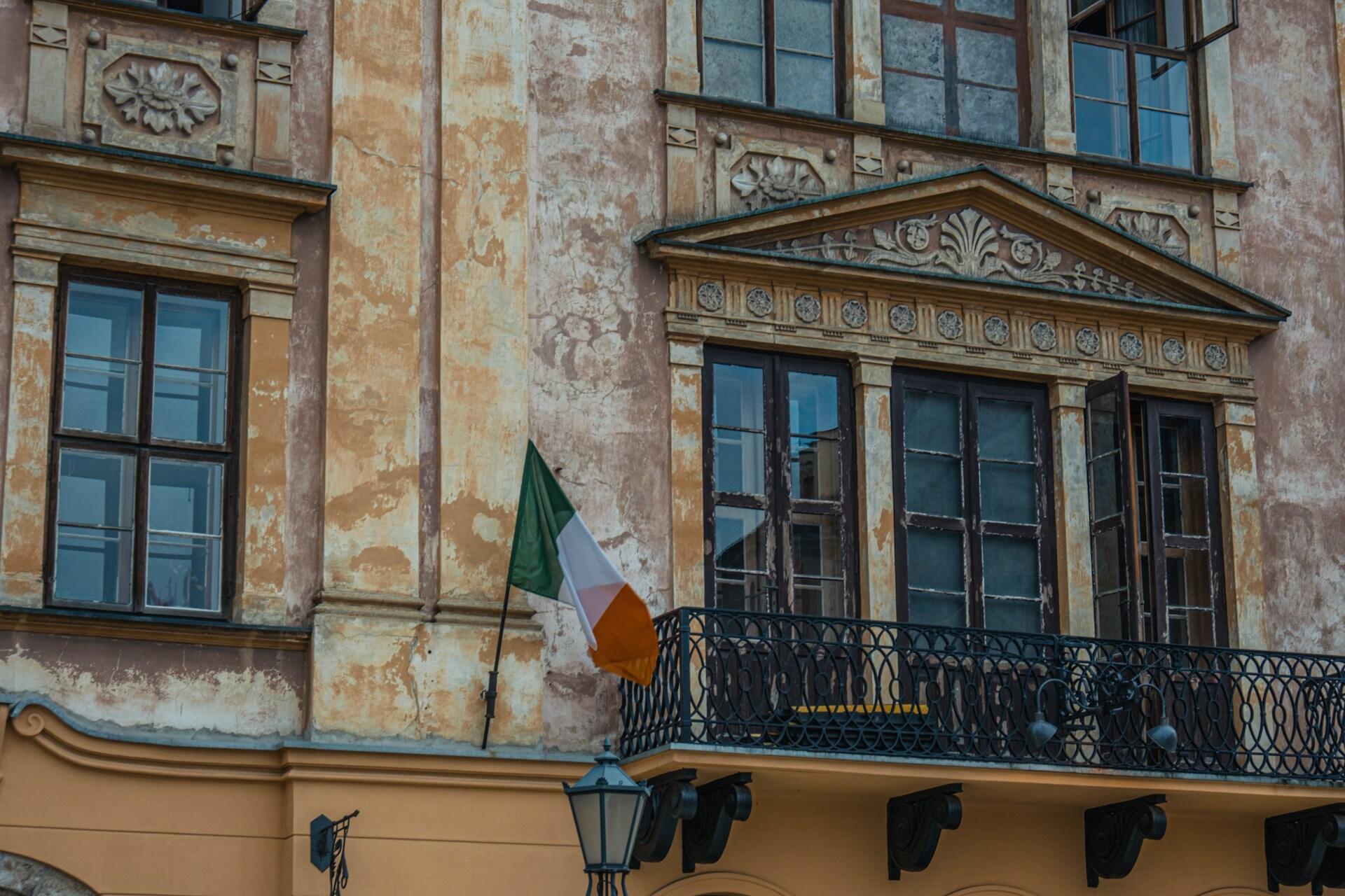 Irlands flagg hengende fra en bygning med gammel fasade.