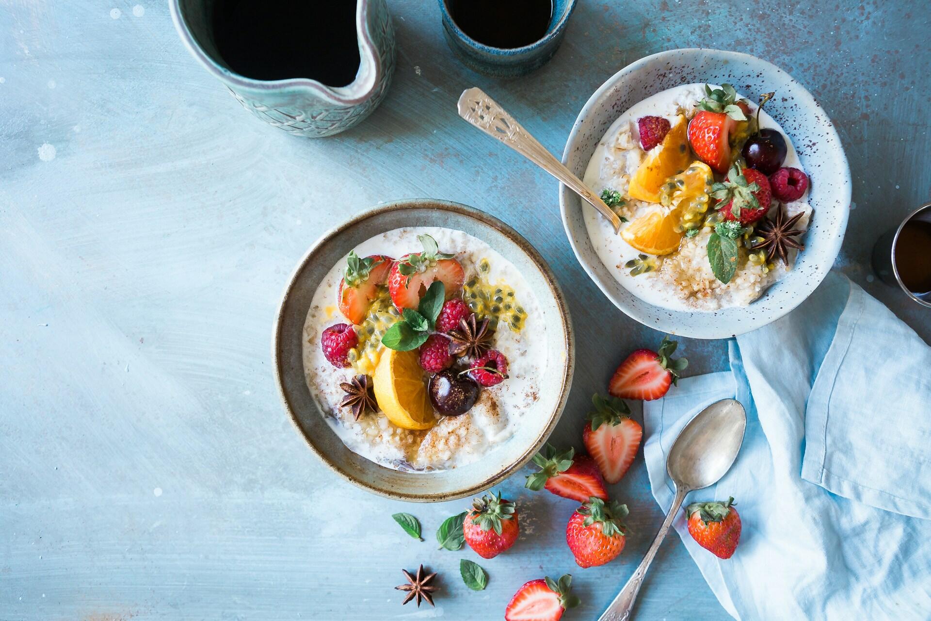 skåler med yoghurt og grøt med frukt som topping