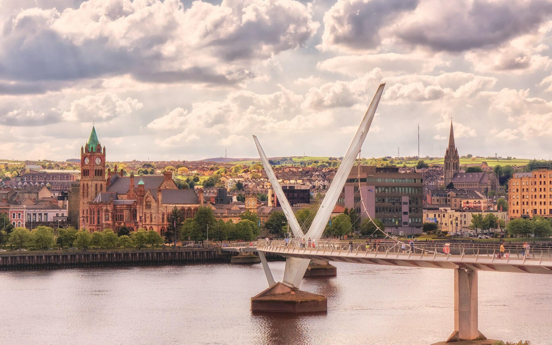 Peace Bridge i Londonderry med byens historiske bygninger i bakgrunnen.