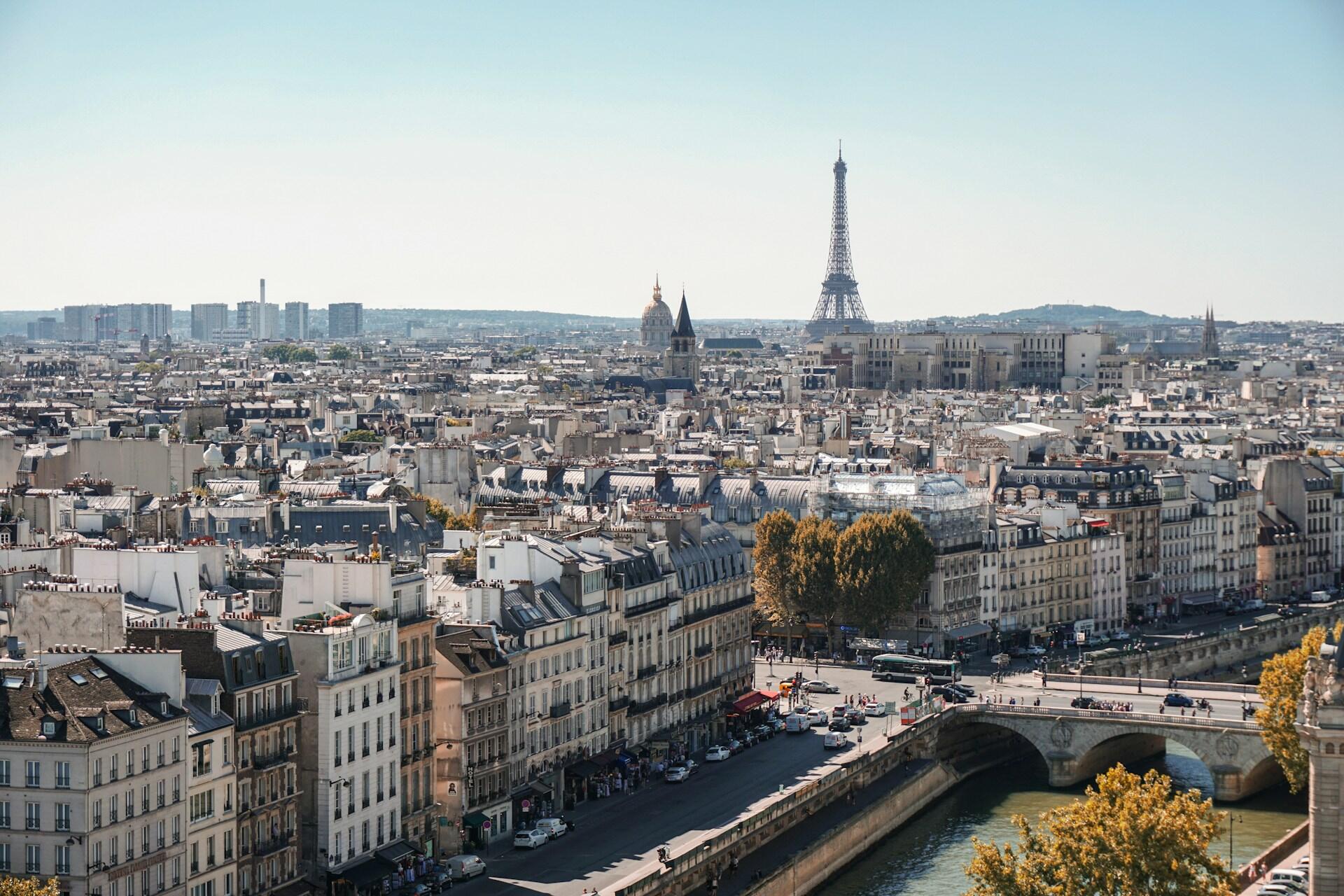 Overblikksbilde av Paris på en solfylt dag med Eiffeltårnet i horisonten