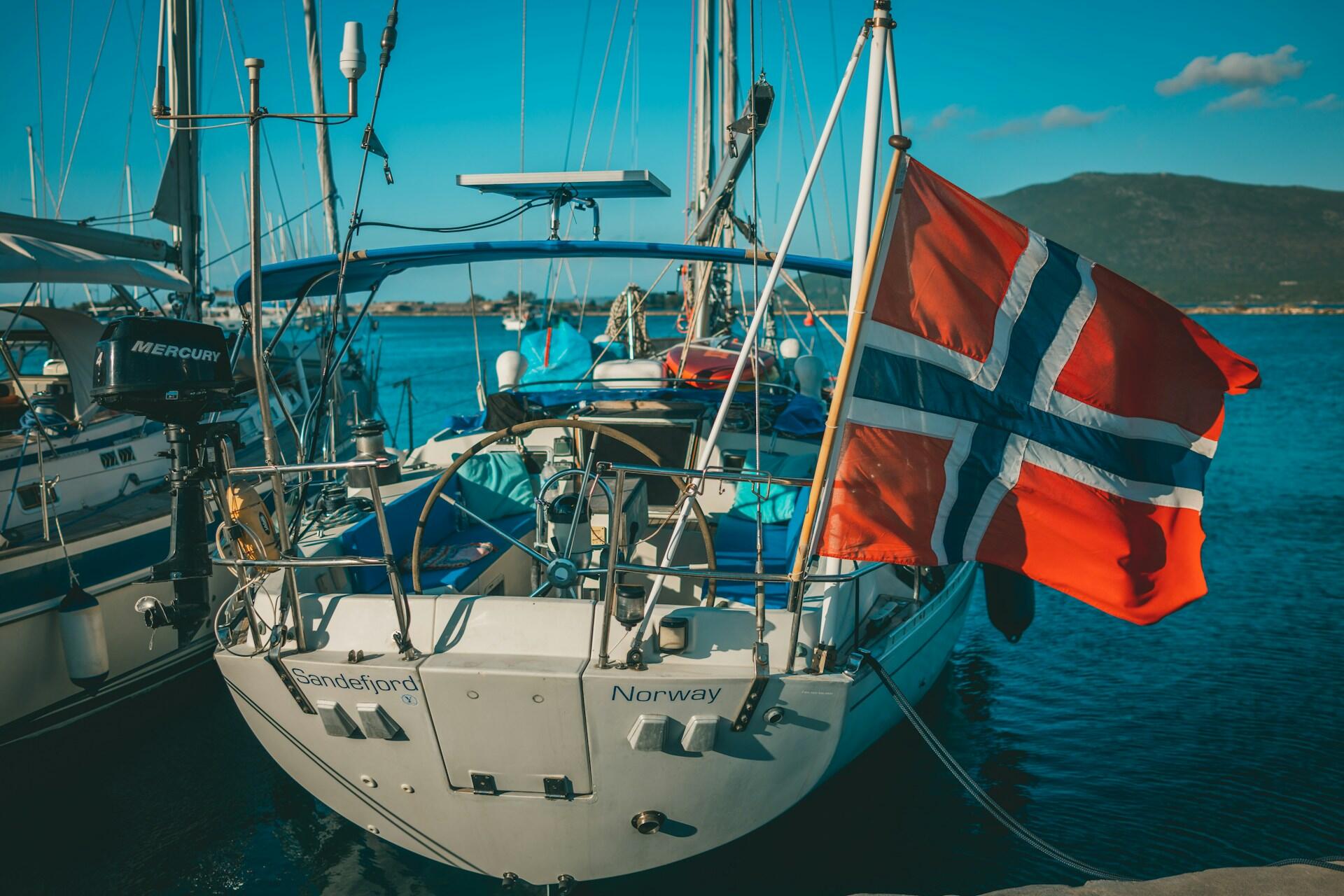 Norsk seilbåt med flagg i havn – symbol på velstand og velferdsstat