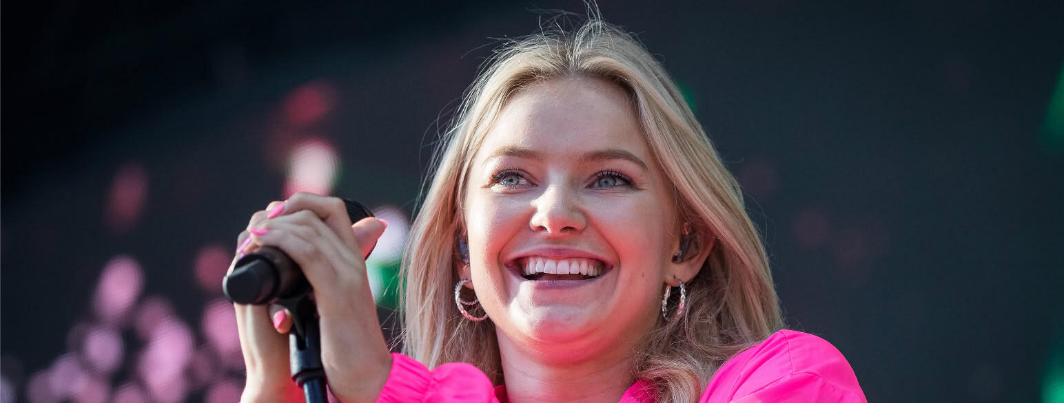 Artisten Astrid S med mikrofon og rosa overdel som