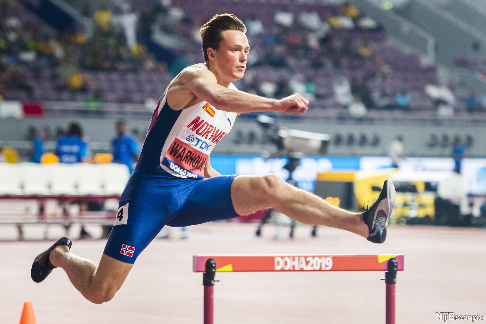 Friidrettsutøver Karsten Warholm løper hekk på en bane