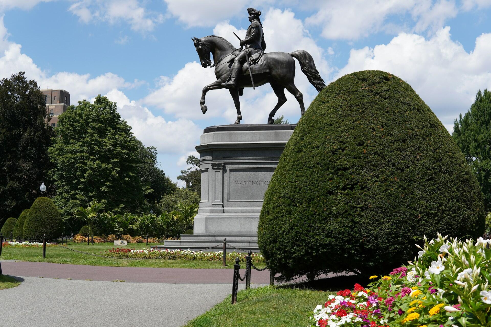 Rytterstatue av George Washington i Boston Public Garden omgitt av blomster og trær.
