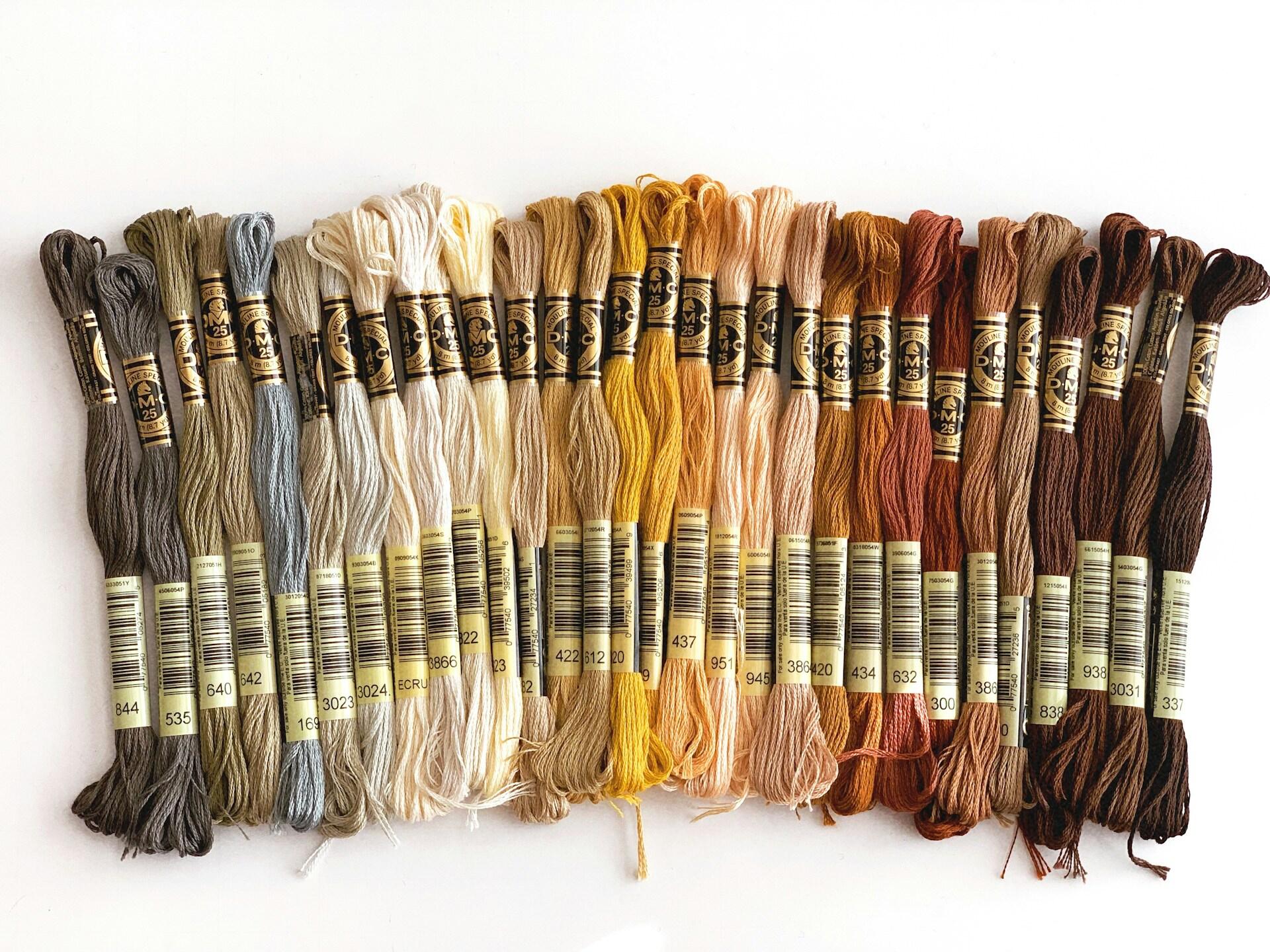 Broderitråder i ulike farger på rekke og rad