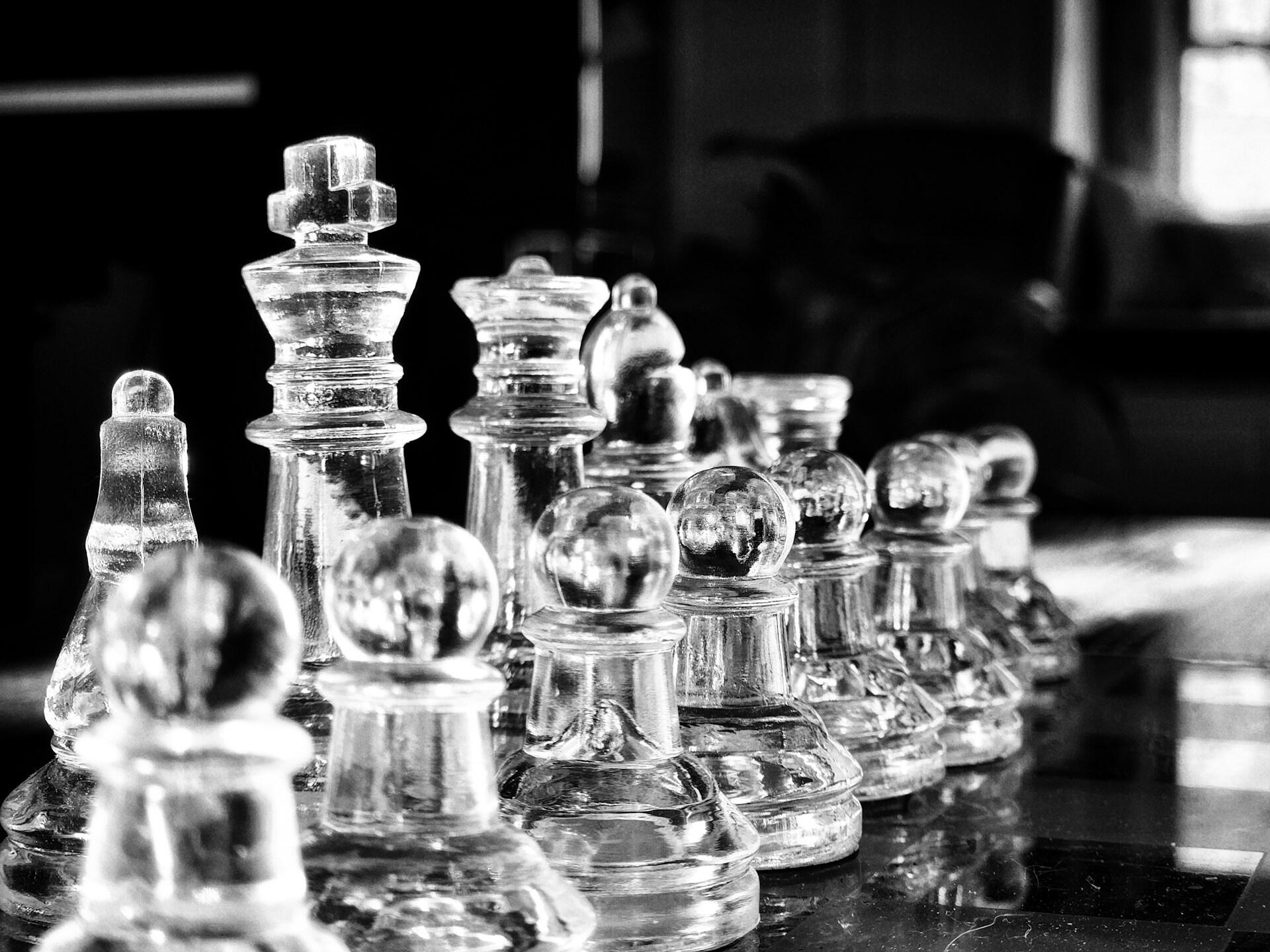 Sjakkbrikker i glass stilt opp på brett