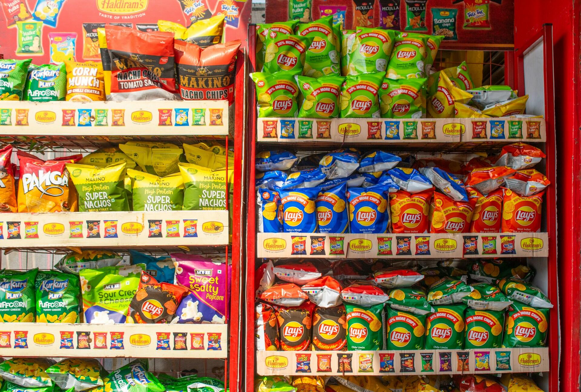 Butikkhylle med chips og snacks som viser vanlige fristelser i hverdagen.