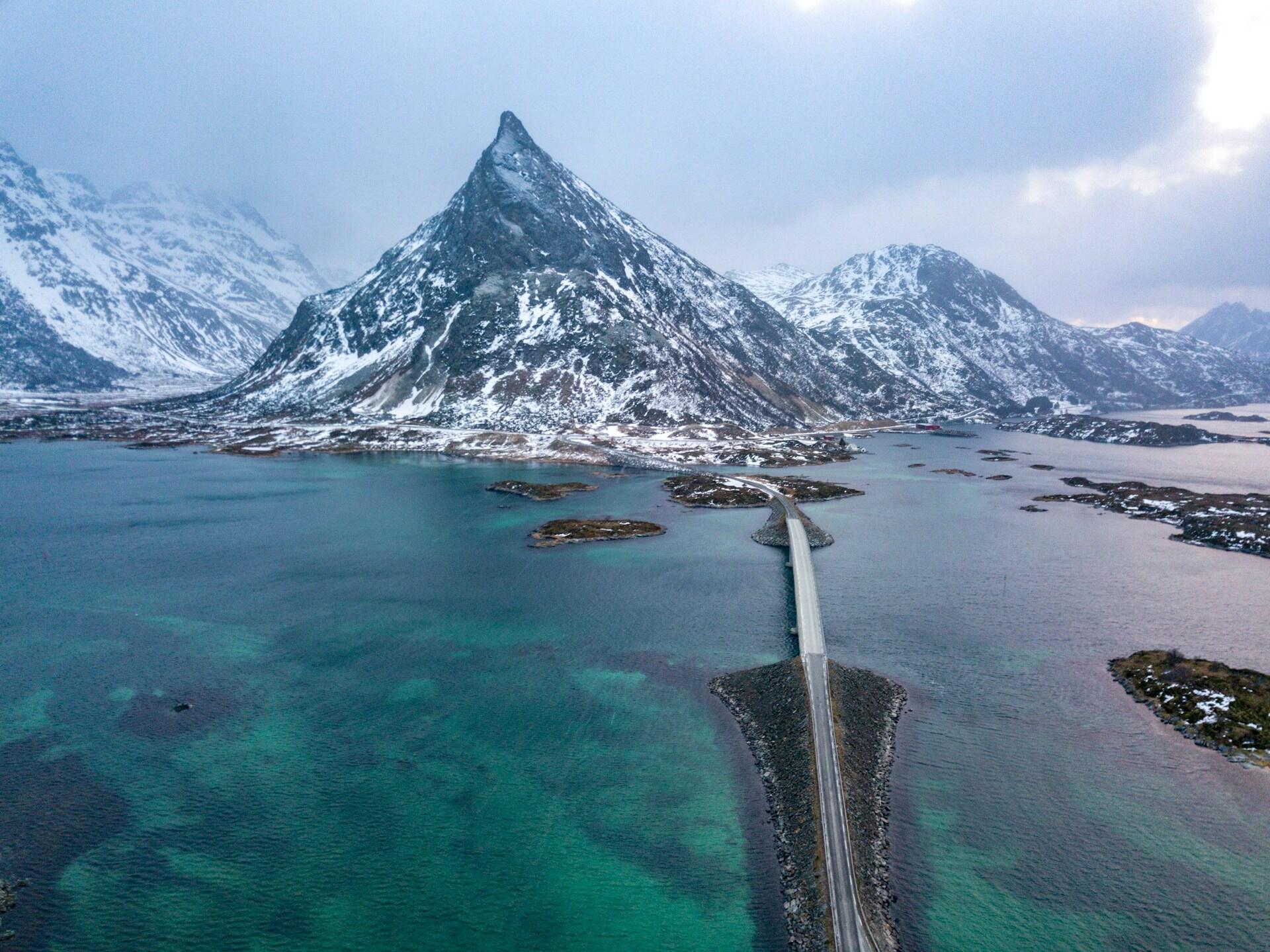Fjell og broforbindelse over turkist hav ved Fredvang i Lofoten