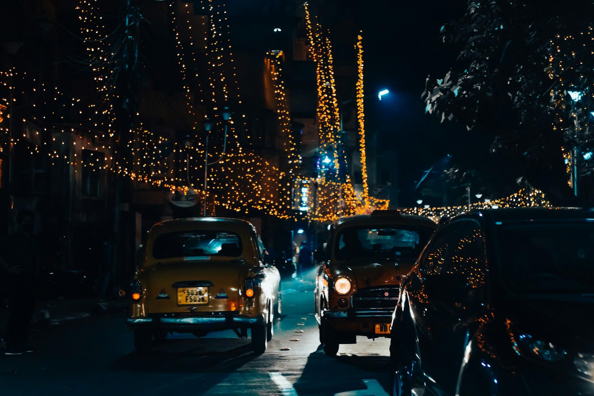 Gatebilde fra en internasjonal by om natten med biler og lys