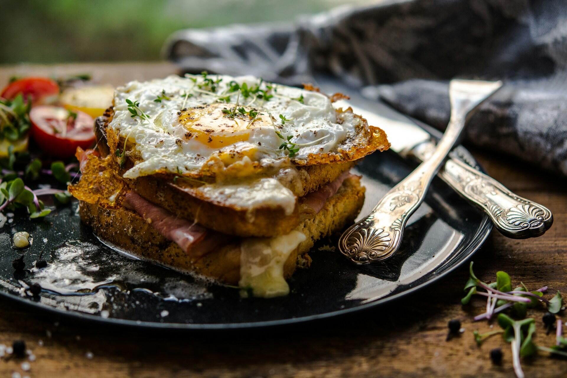 Croque madame med sølvbestikk ved siden av
