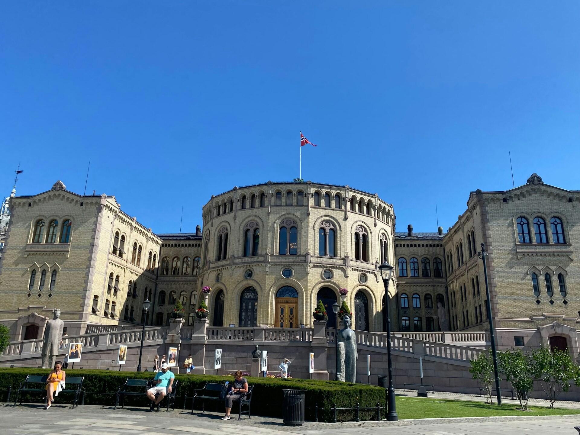 Stortinget i Oslo med blå himmel i bakgrunnen