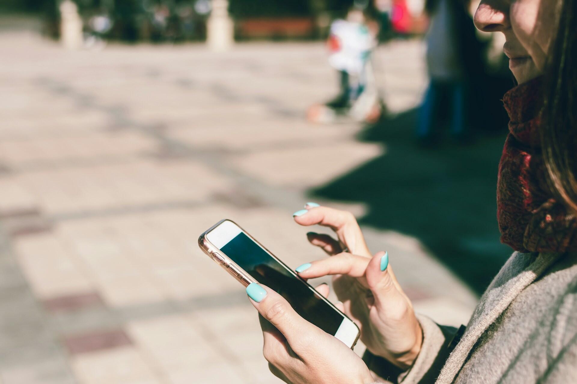 Dame scroller og trykker på mobilen sn