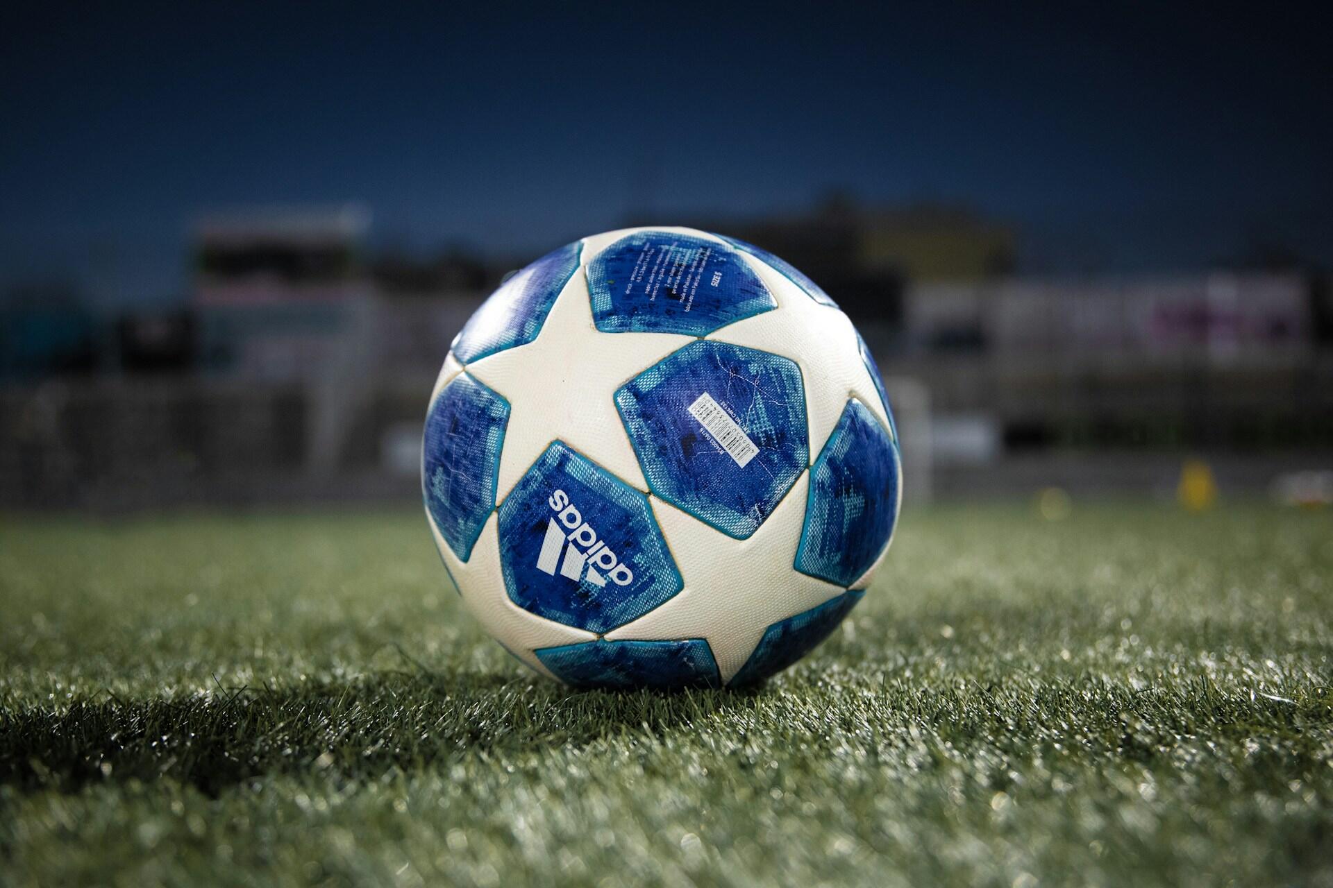 blå og hvit fotball med stjerner ligger på gresset