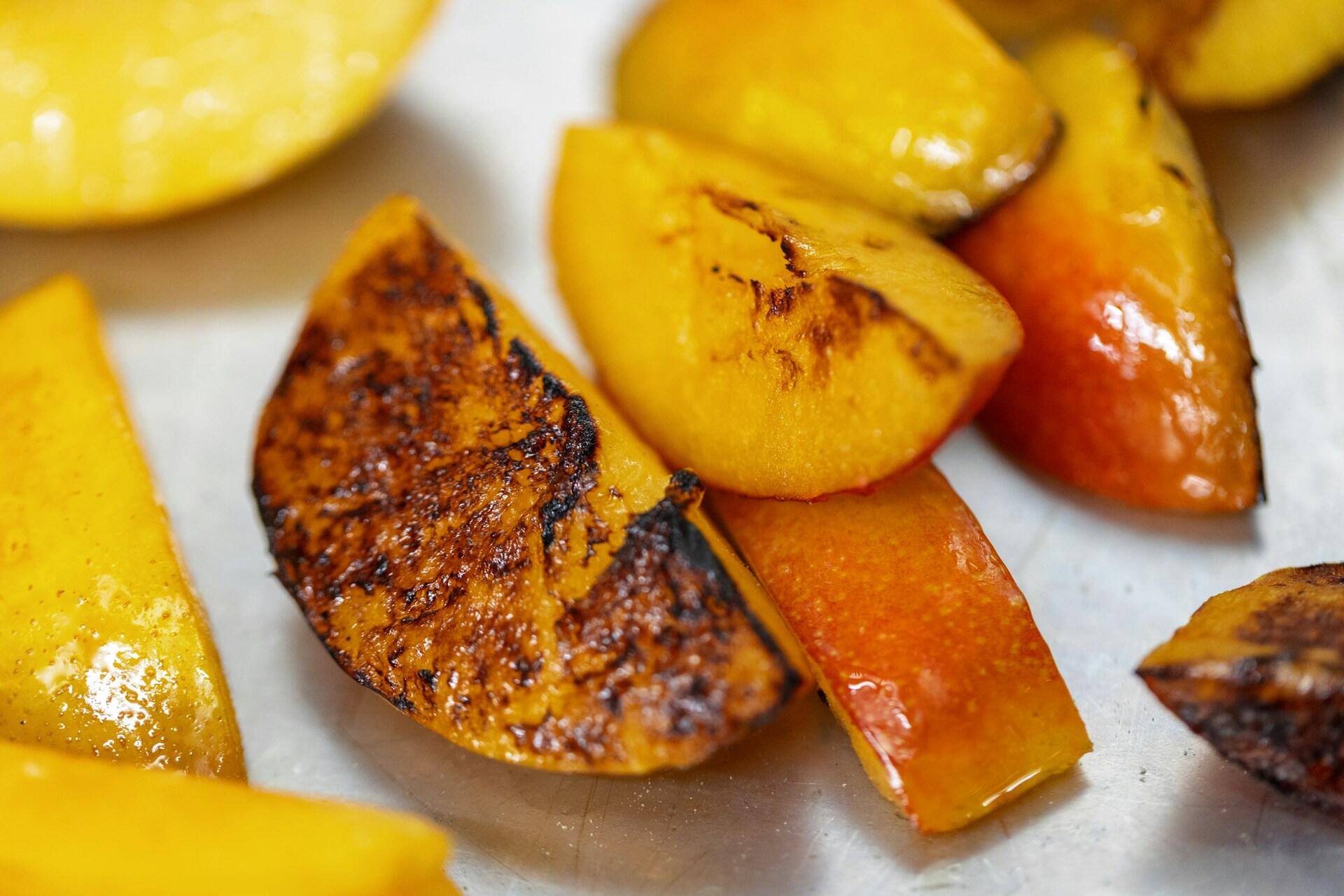 Grillede fruktskiver med karamellisert overflate, klare til servering som dessert på grill.