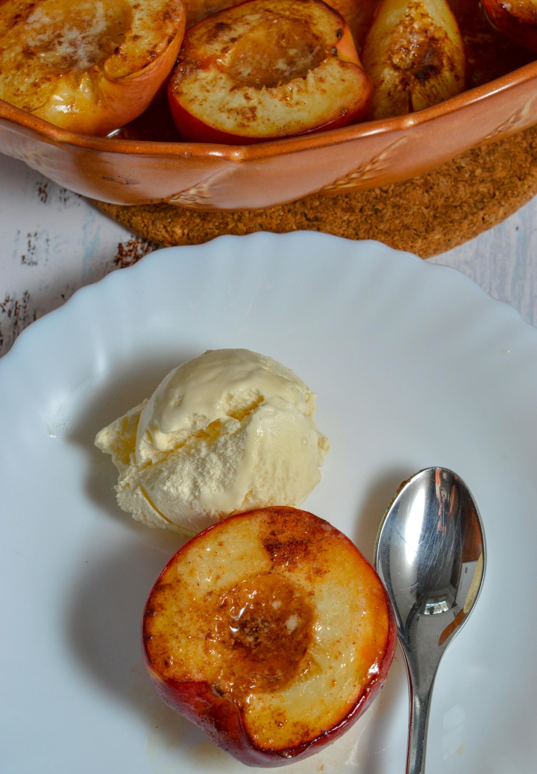 Grillet fersken med kanel og vaniljeis servert som enkel dessert på grill.