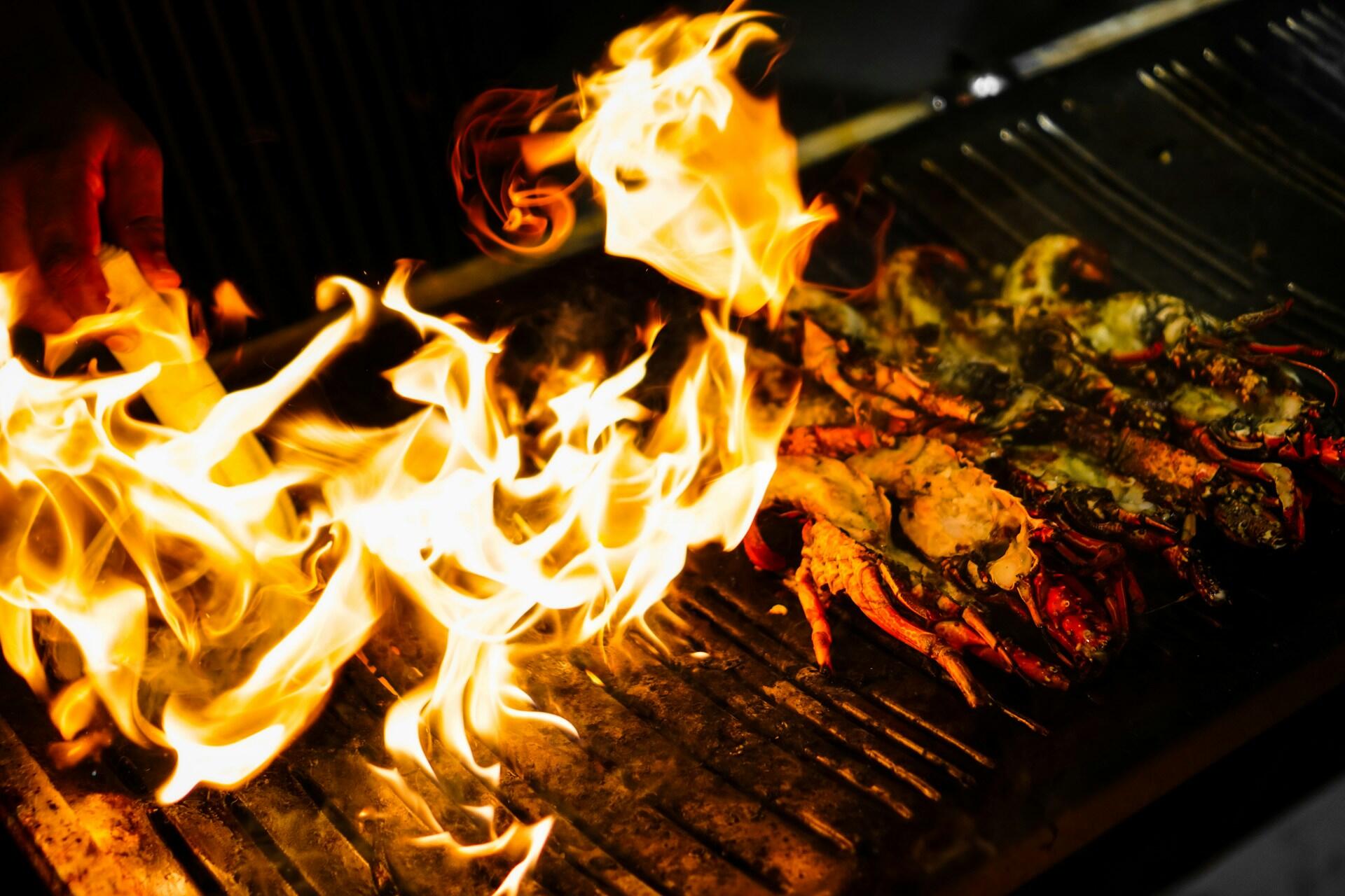 Store flammer på grill under tilberedning av mat