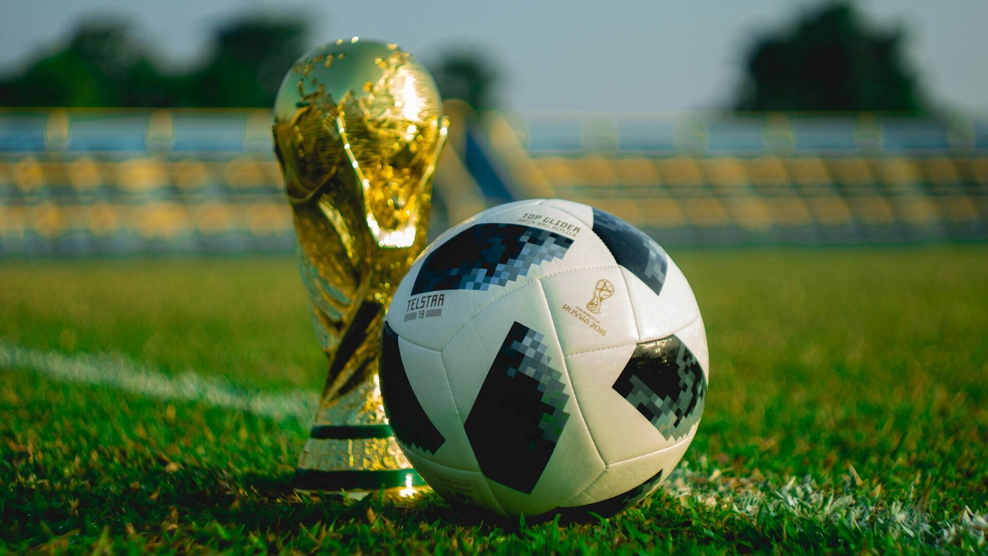 vm trofe og fotball på gressbane