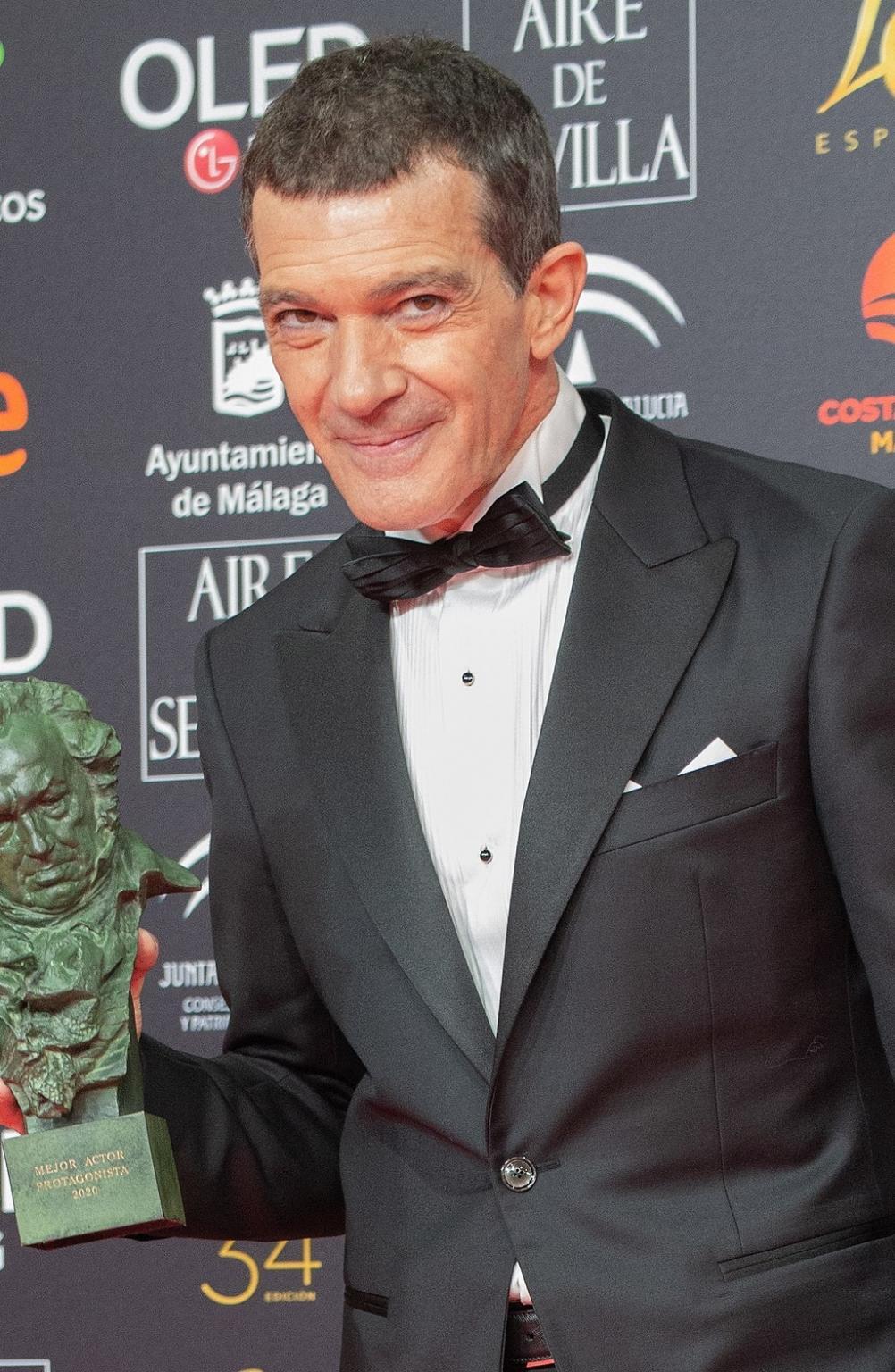 Antonio Banderas i smoking med en filmpris i hånden.