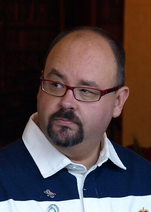 Portrett av den spanske forfatteren Carlos Ruiz Zafón med røde briller.