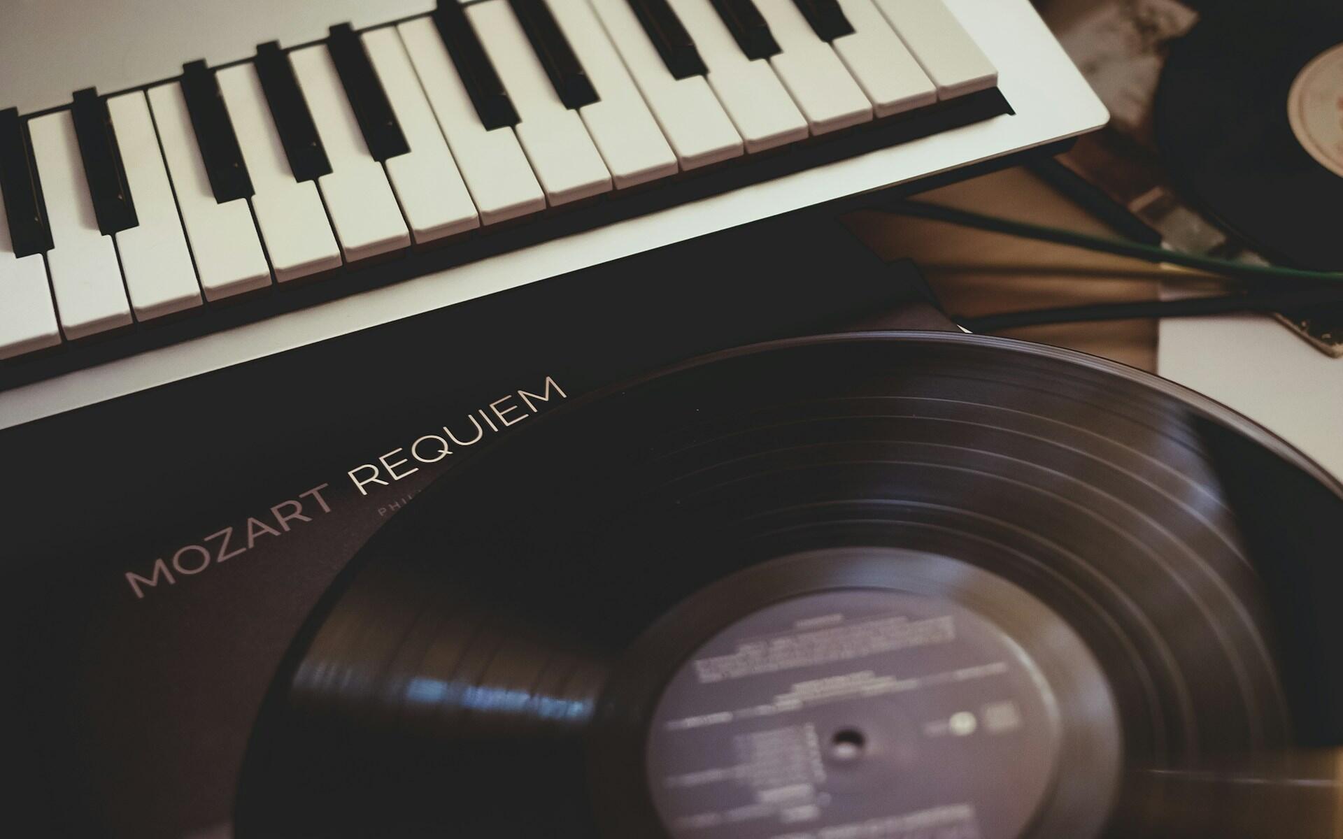Keyboard ved siden av en vinylplate med Mozarts Requiem.